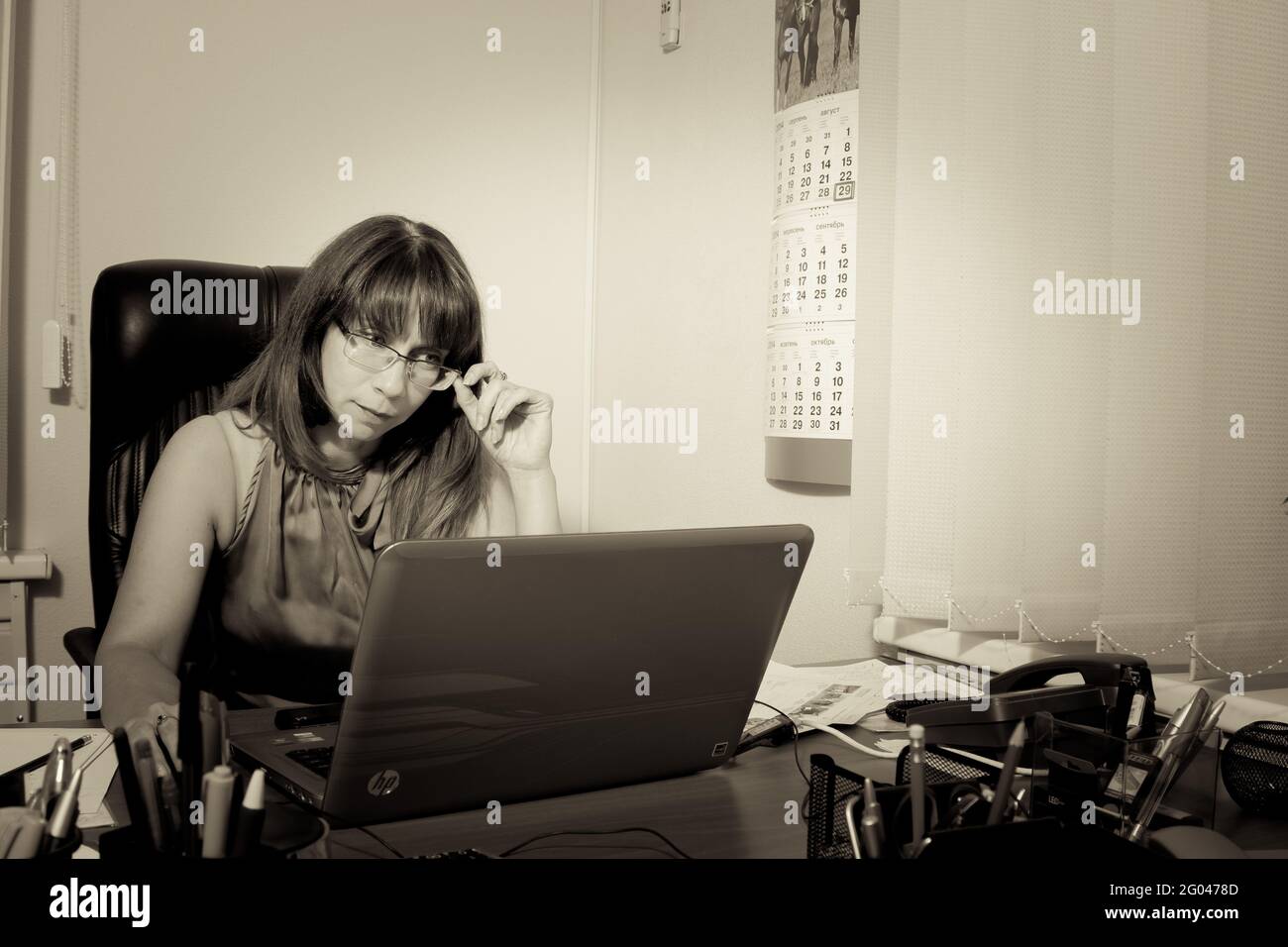 Porträt einer jungen Frau an ihrem Arbeitsplatz im Büro. Lifestyle-Konzept von Menschen, die in modernen Büros unter Tageslicht arbeiten. Stockfoto