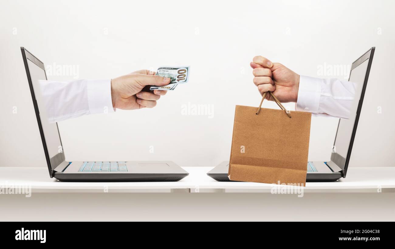 Der Käufer gibt Geld für das Produkt, und der Verkäufer zeigt eine Feige anstelle eines Produkts, ein Konzept zum Thema Online-Betrug beim Online-Shopping. Stockfoto
