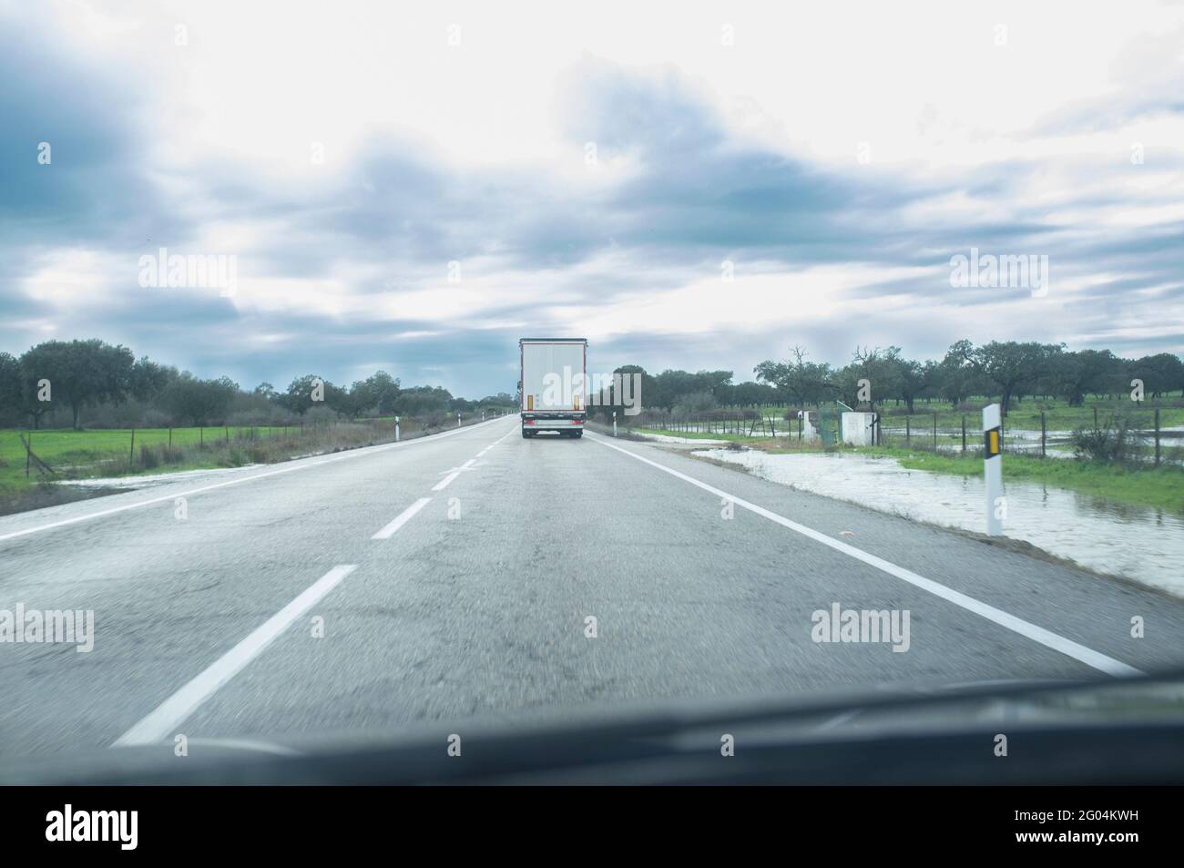 Fahren hinter einem LKW unter anhaltendem Nieselregen. Fahrkonzept bei schlechtem Wetter Stockfoto