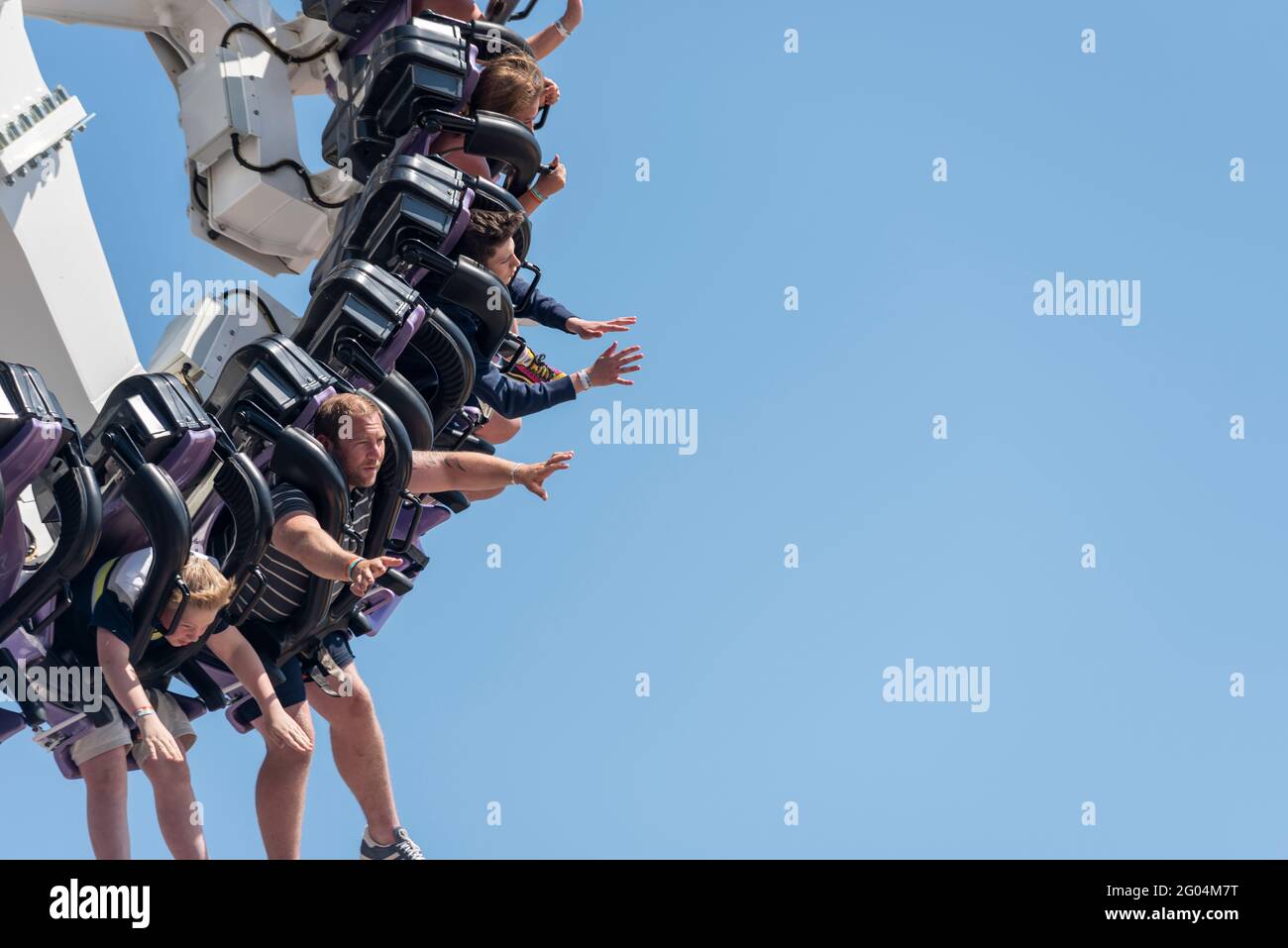 Die Menschen auf der Achse Thrill Ride in Adventure Island am Ende Mai an den Bankfeiertagen in Southend on Sea, Essex, Großbritannien, bei hellem, sonnigem Wetter Stockfoto