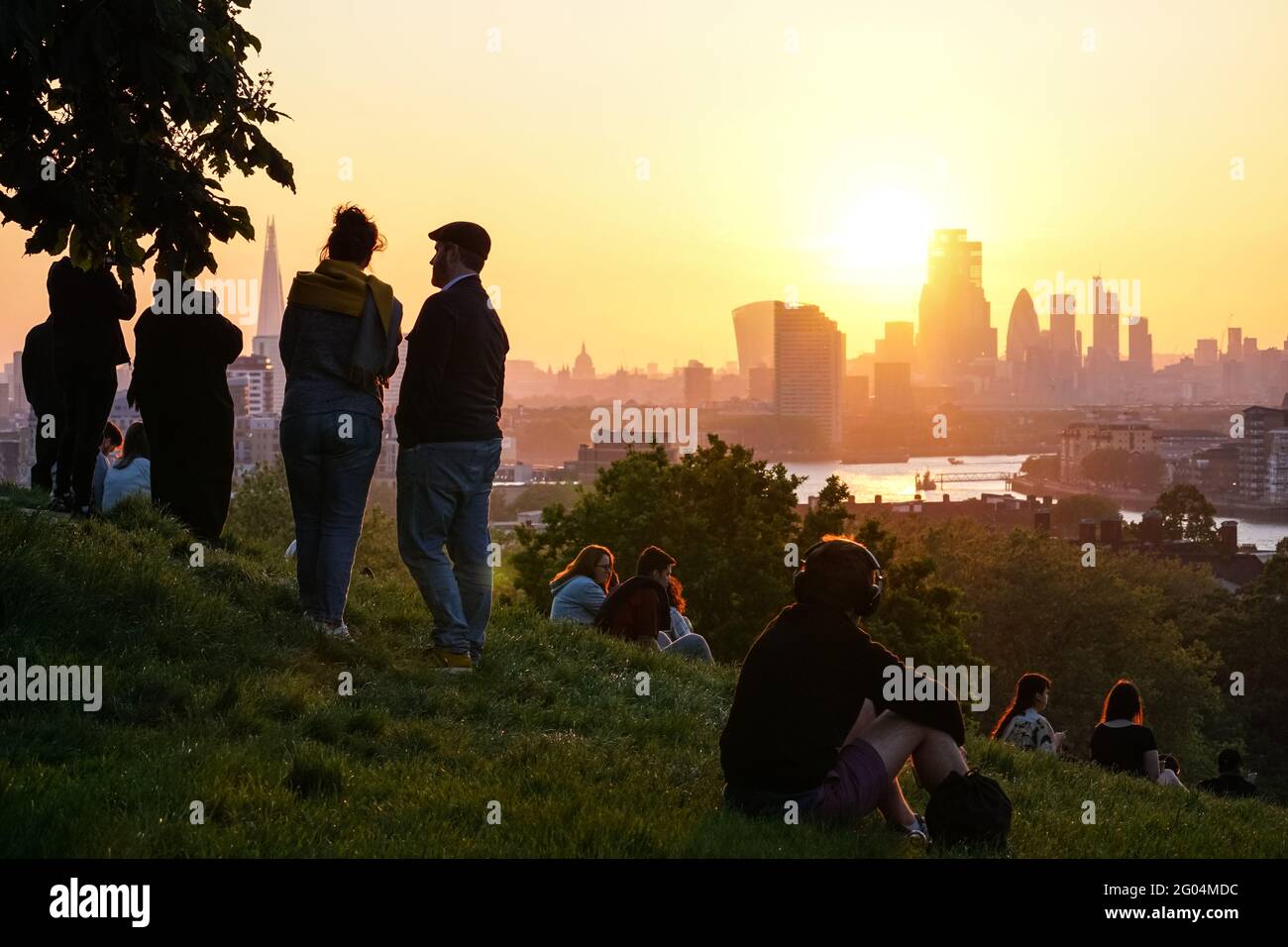 Menschen beobachten den Sonnenuntergang in Greenwich Park, London, England, Großbritannien, Großbritannien Stockfoto