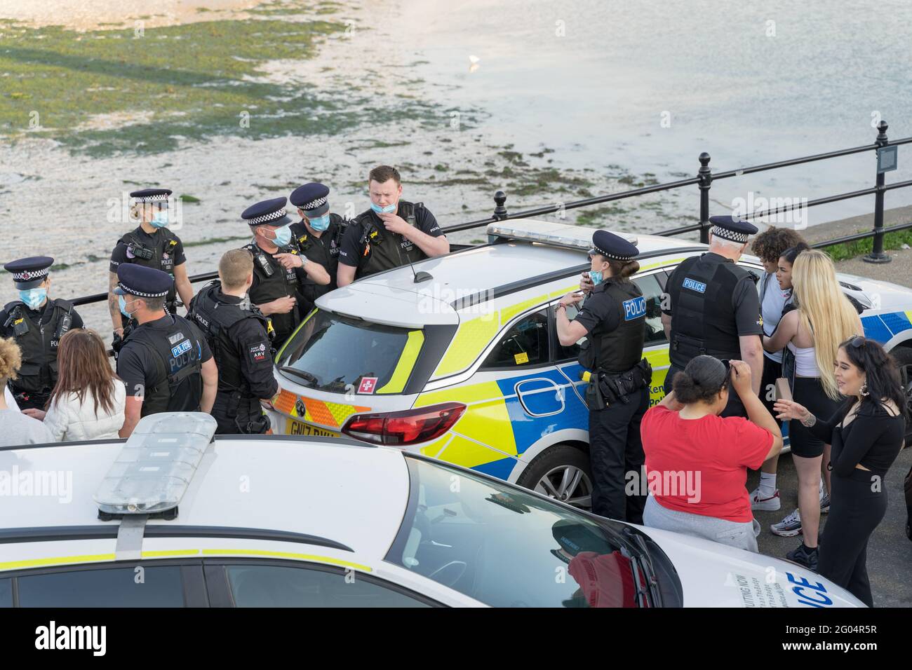 am Montag, feiertag, spricht Polece mit Partygängern vor der Lighthouse Bar, Margate, nachdem sie einen Mann in ein markiertes Polizeiauto, England, verhaften Stockfoto