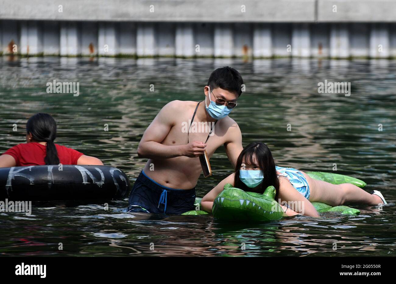 Apopka, Usa. Mai 2021. Menschen mit Gesichtsmasken kühlen sich am Memorial Day in einem Schwimmbad im Kelly Park ab. Da die Coronavirus-Fälle in den Vereinigten Staaten immer weiter abfallen, genießen die Menschen Urlaubsaktivitäten, viele zum ersten Mal seit über einem Jahr. Kredit: SOPA Images Limited/Alamy Live Nachrichten Stockfoto