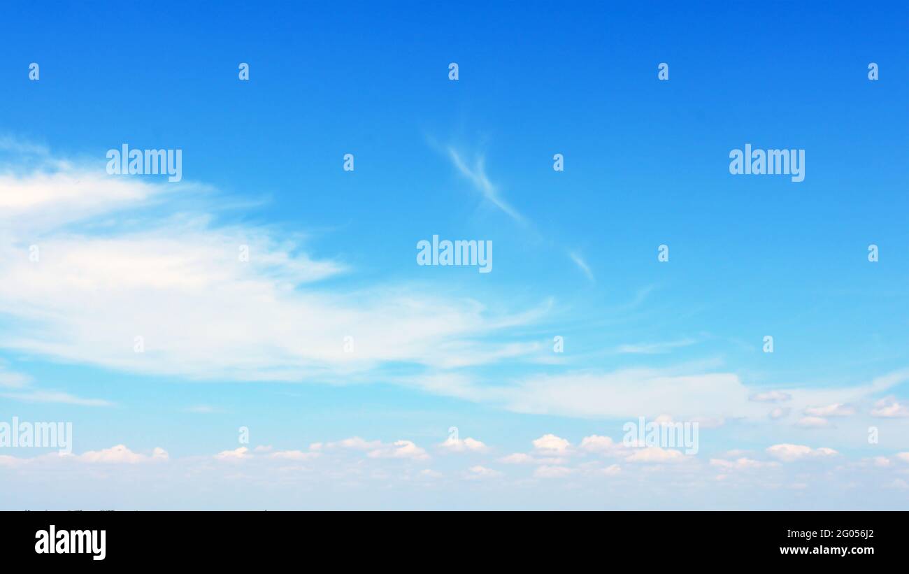 Verschwommene weiße Wolken schweben am blauen Himmel und können als Banner, Poster oder Tapete verwendet werden. Stockfoto