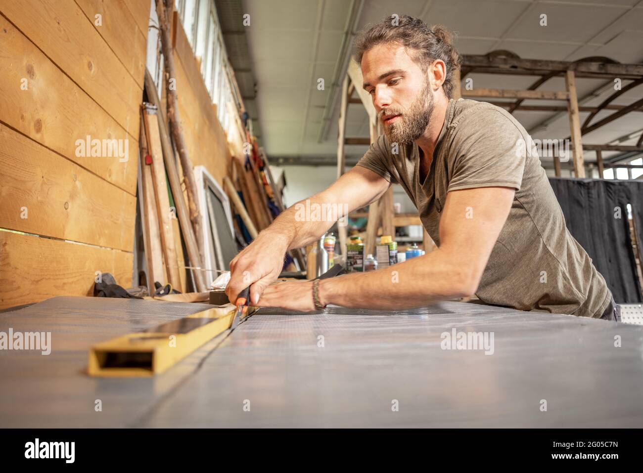 Mann, der ein Gebrauchsmesser auf einer Werkbank verwendet Stockfoto