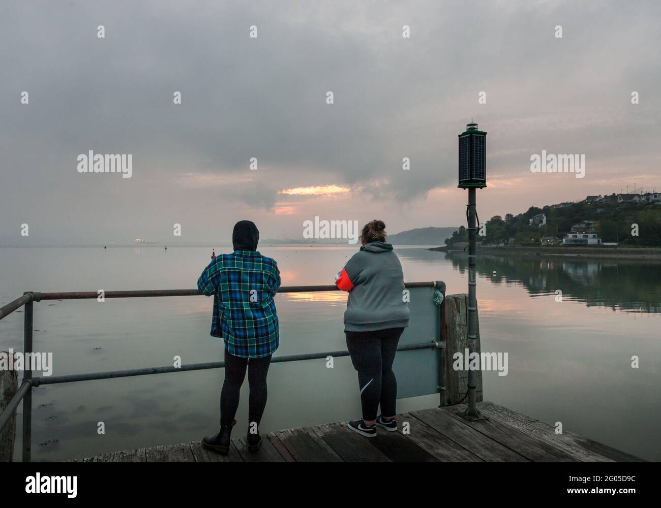 Currabinny, Cork, Irland. Juni 2021. Zwei Frauen waren früh aufgestanden, um die Morgenröte am Currabinny Pier, Co. Cork, Irland, zu beobachten. - Credit; David Creedon / Alamy Live News Stockfoto