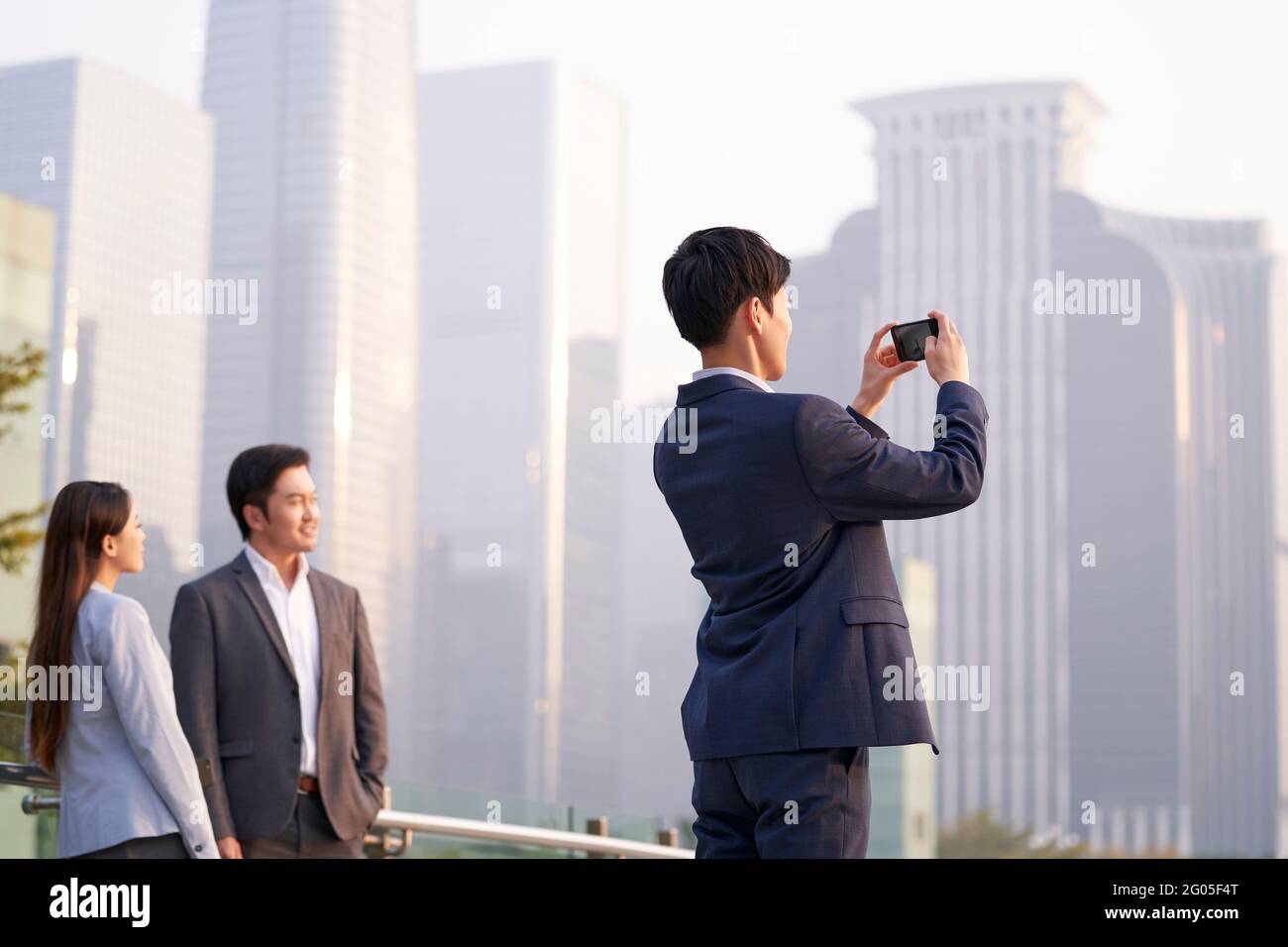 Junger asiatischer Geschäftsmann, der ein Bild von der Stadt gemacht hat Mobiltelefon verwenden Stockfoto
