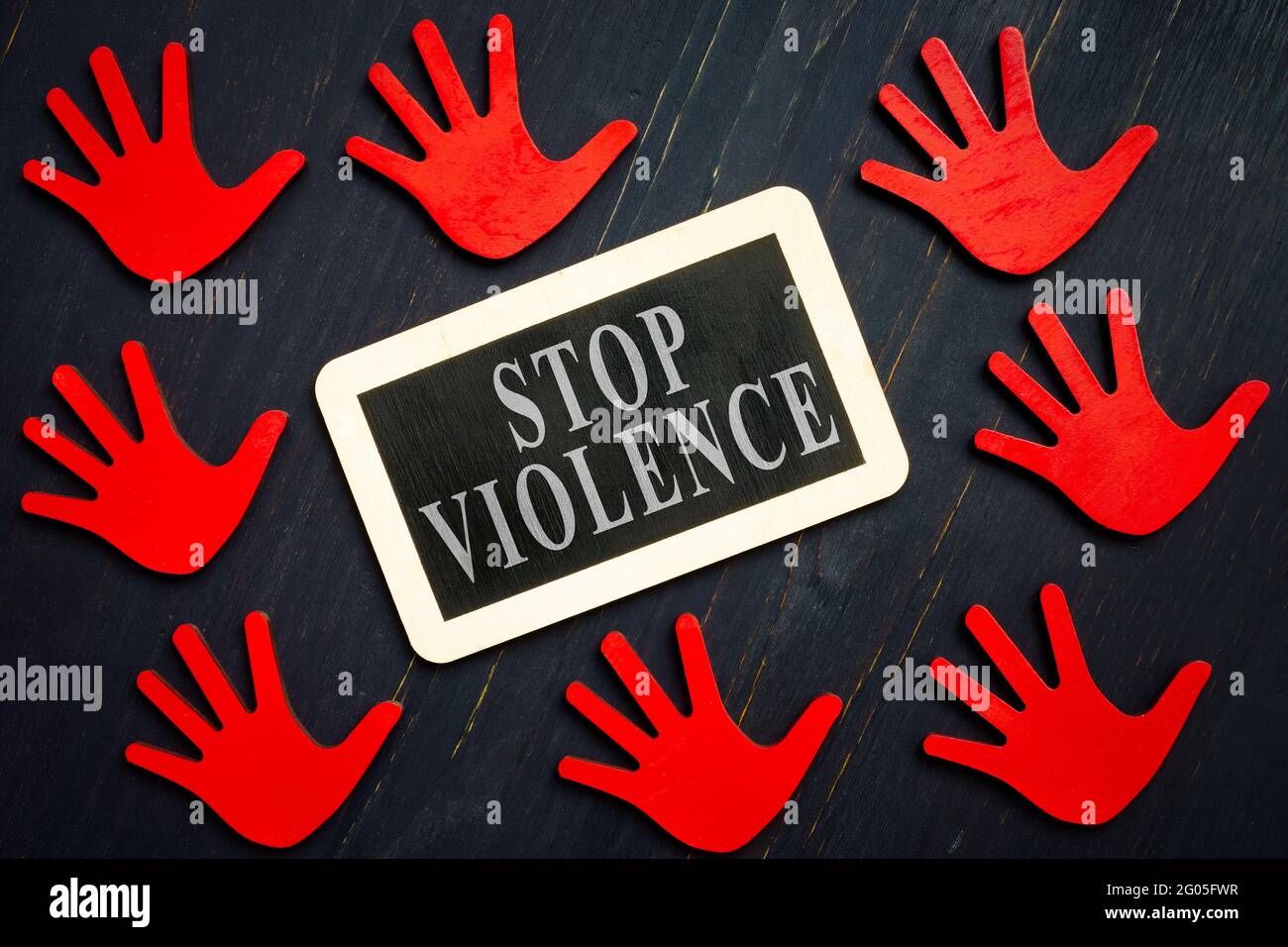 Stop Gewalt Zeichen und rote Hände auf der dunklen Oberfläche. Stockfoto