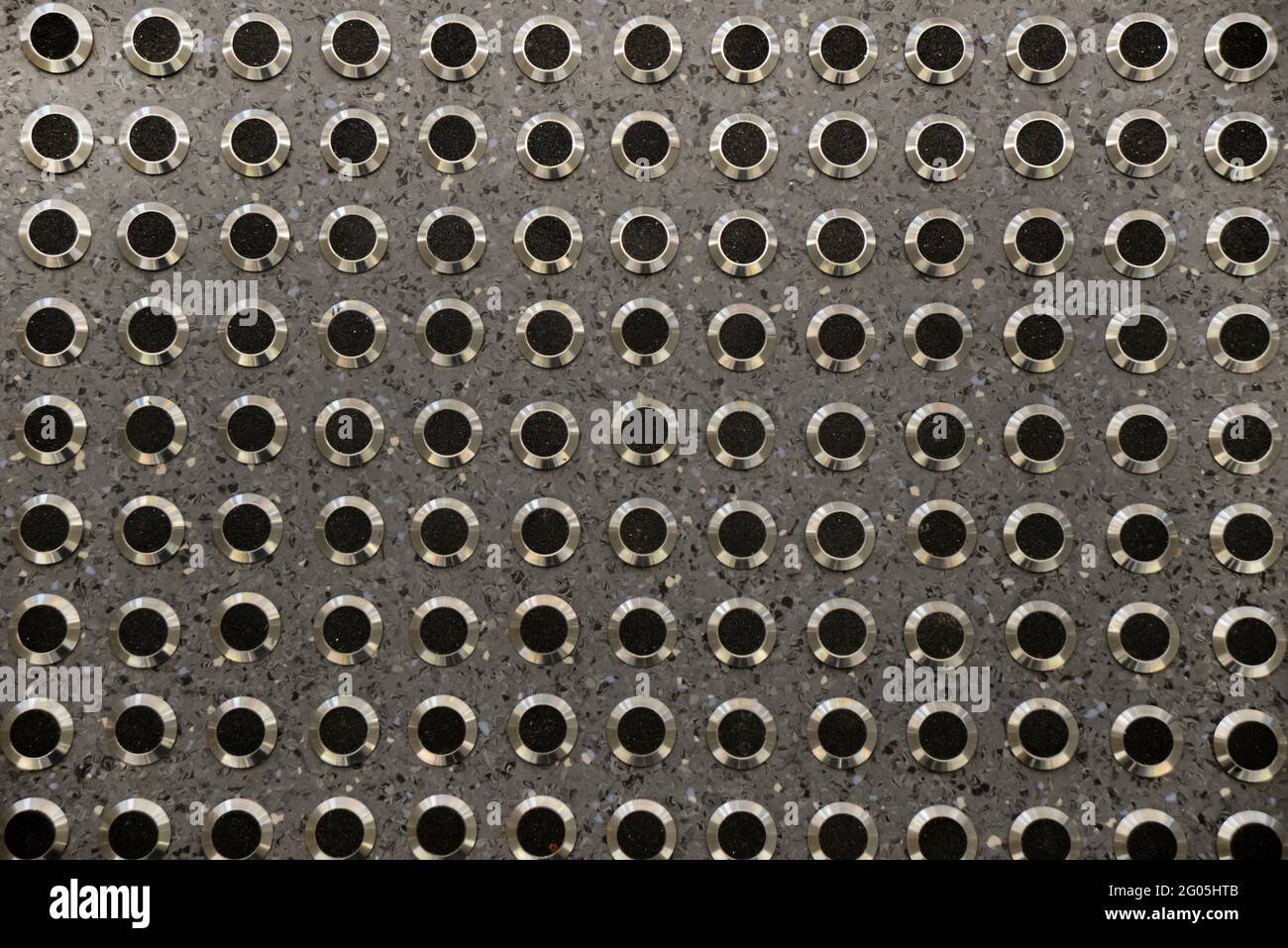 Details von erhöhten Metall- und Gummistollen auf neuen Bodenbelägen Erzeugt einen strukturierten Hintergrund Stockfoto