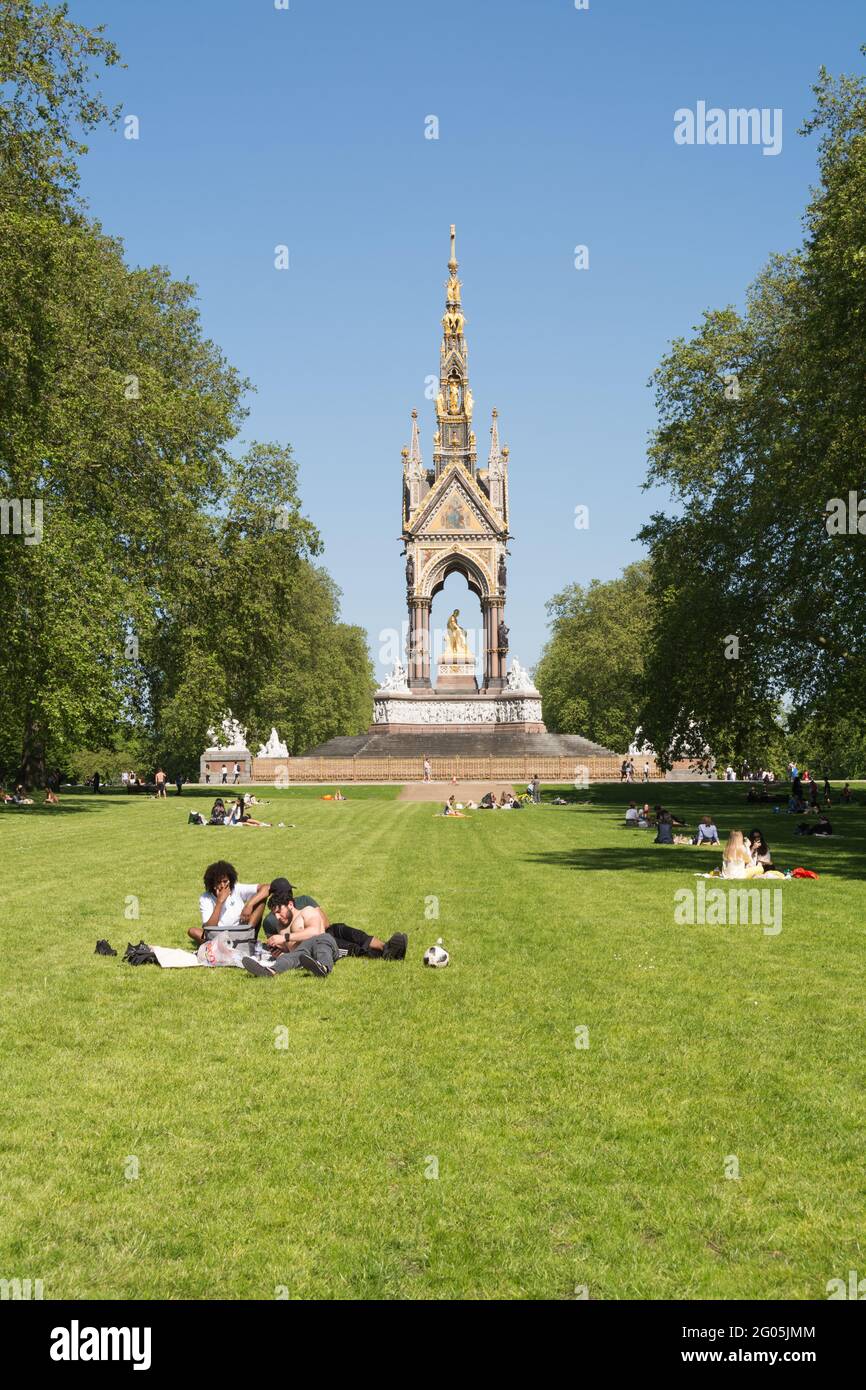 Junge Männer entspannen sich am Montag an den Bankfeiertagen vor dem Albert Memorial, Kensington Gardens, Kensington, London, W8, England, Großbritannien Stockfoto