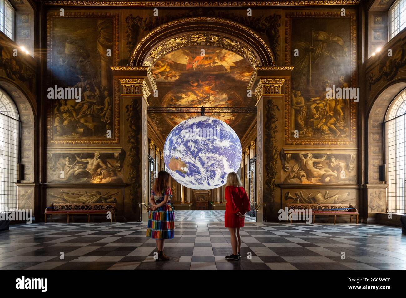 London, Großbritannien, 1. Juni 2021. Mitarbeiter sehen die „Gaia“ des Künstlers Luke Jerram, die in der Painted Hall des Old Royal Naval College in Greenwich installiert wurde. Die maßstabsgetreue Nachbildung der Erde dreht sich langsam, um ein Gefühl für den Overview-Effekt zu vermitteln, den Astronauten erleben, wenn sie die Erde aus dem All sehen. Das Werk ist bis zum 1. Juli zu sehen. Kredit: Stephen Chung / Alamy Live Nachrichten Stockfoto