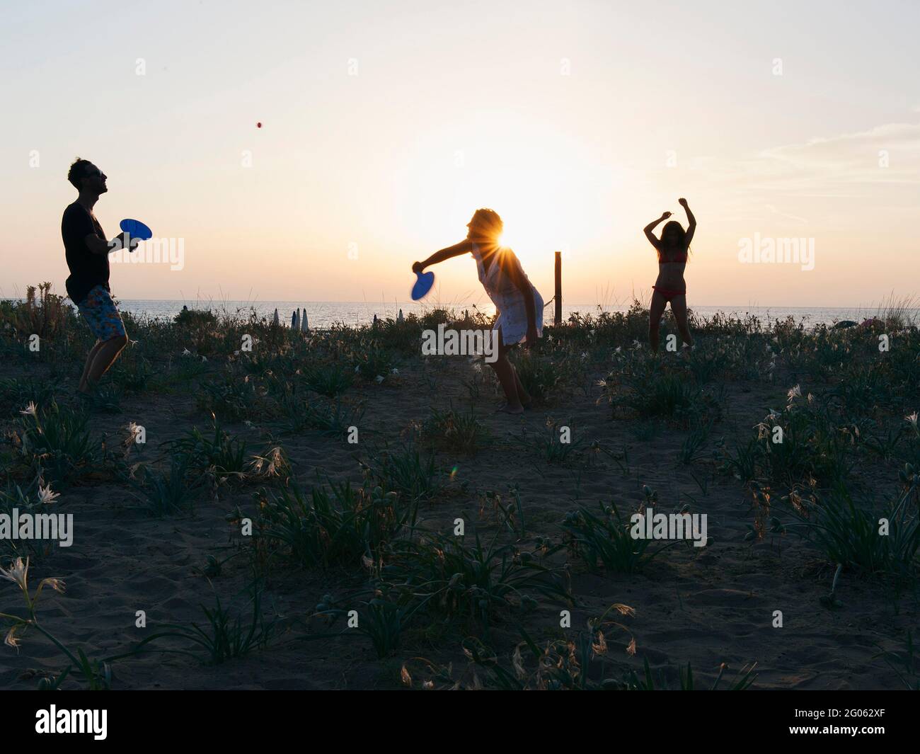 Jungen, die bei Sonnenuntergang am Strand Schlägerball spielen, Ecodorf Maremirtilli, Capacio Paestum, Kampanien, Italien, Europa Stockfoto