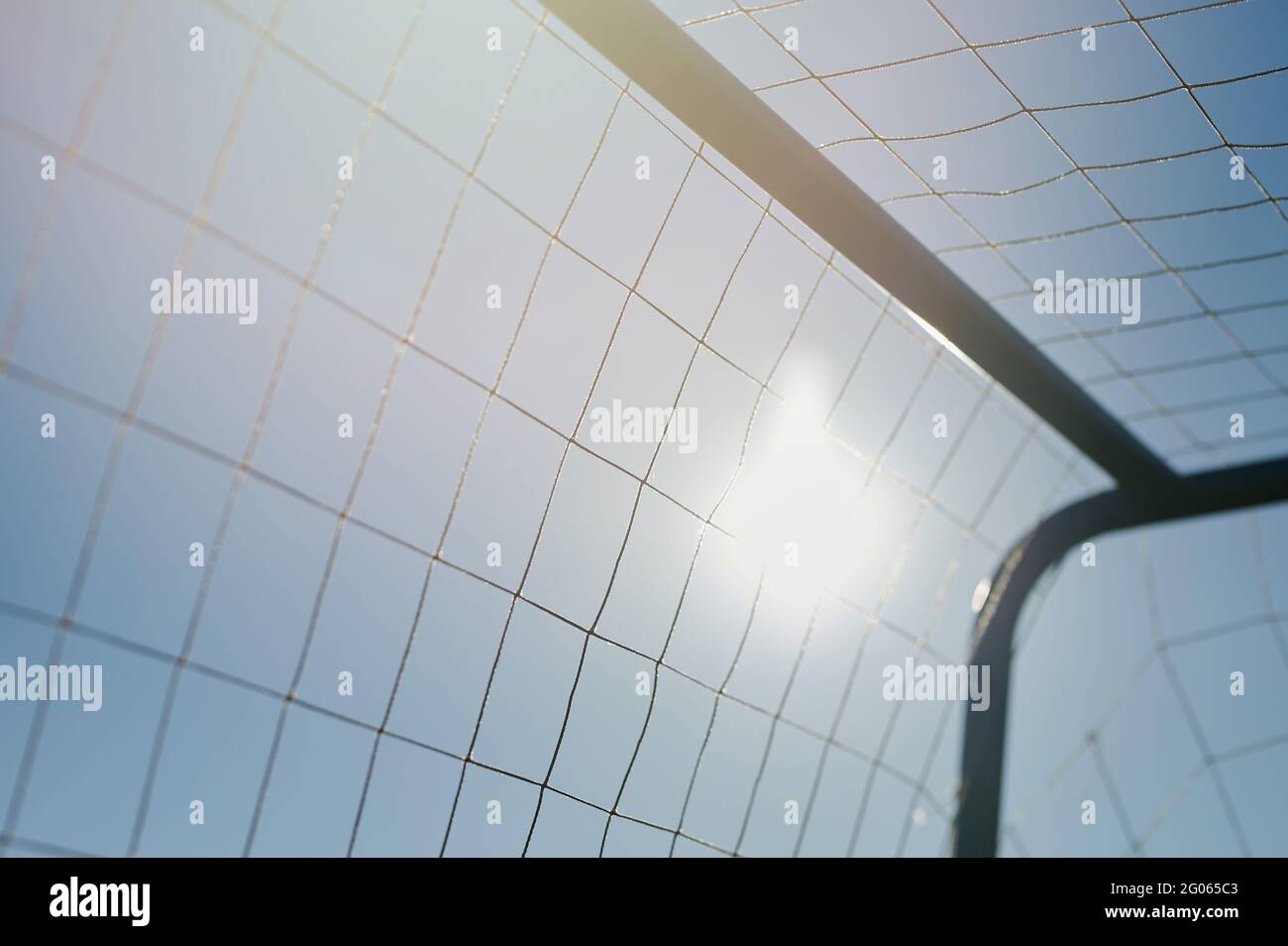 Fußballtor Mesh auf blauem Himmel Hintergrund bei sonnigem Licht Stockfoto