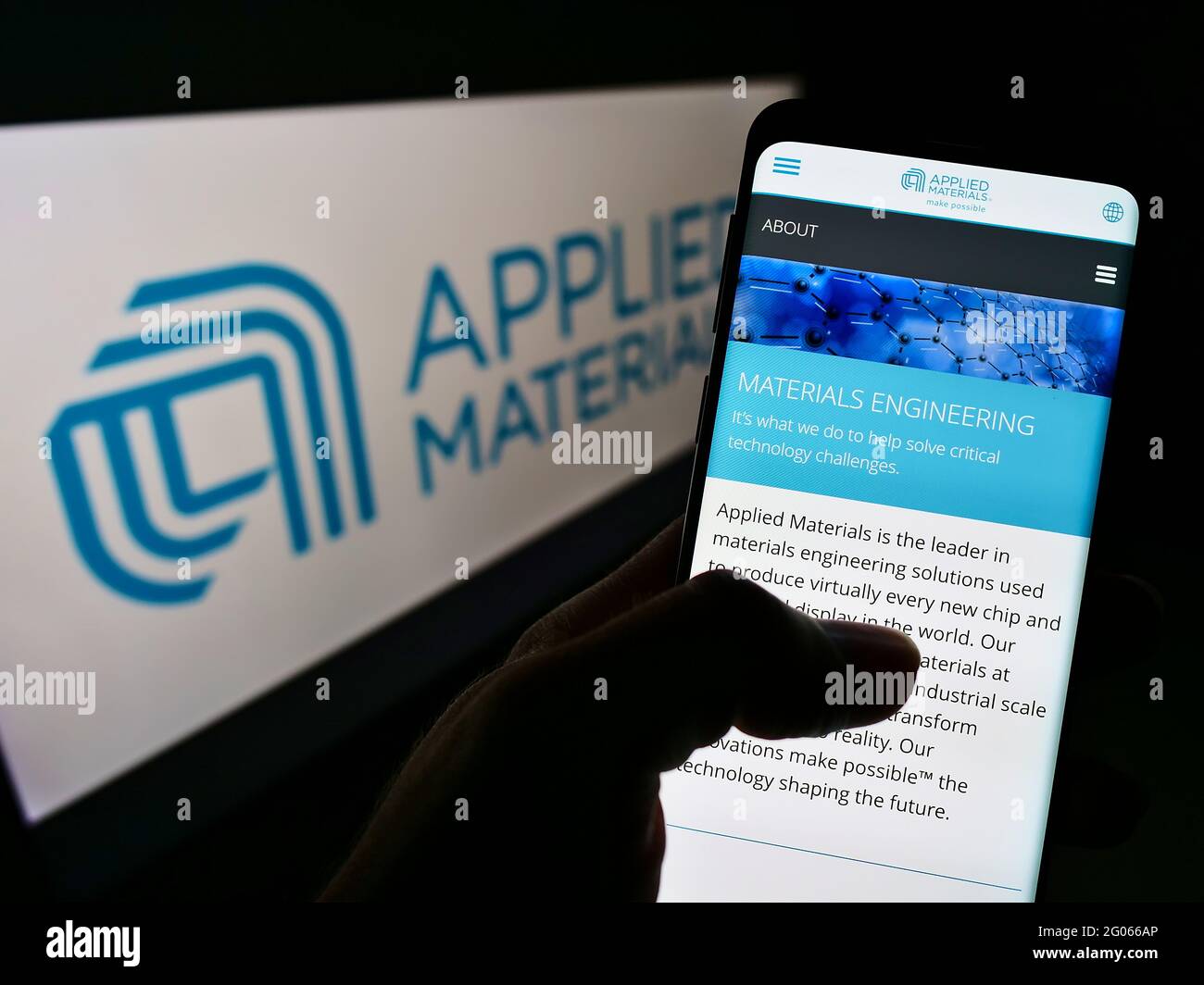 Person, die Mobiltelefon mit der Webseite des US-Halbleiterunternehmens Applied Materials Inc auf dem Bildschirm vor dem Logo hält. Konzentrieren Sie sich auf die Mitte des Telefondisplays. Stockfoto
