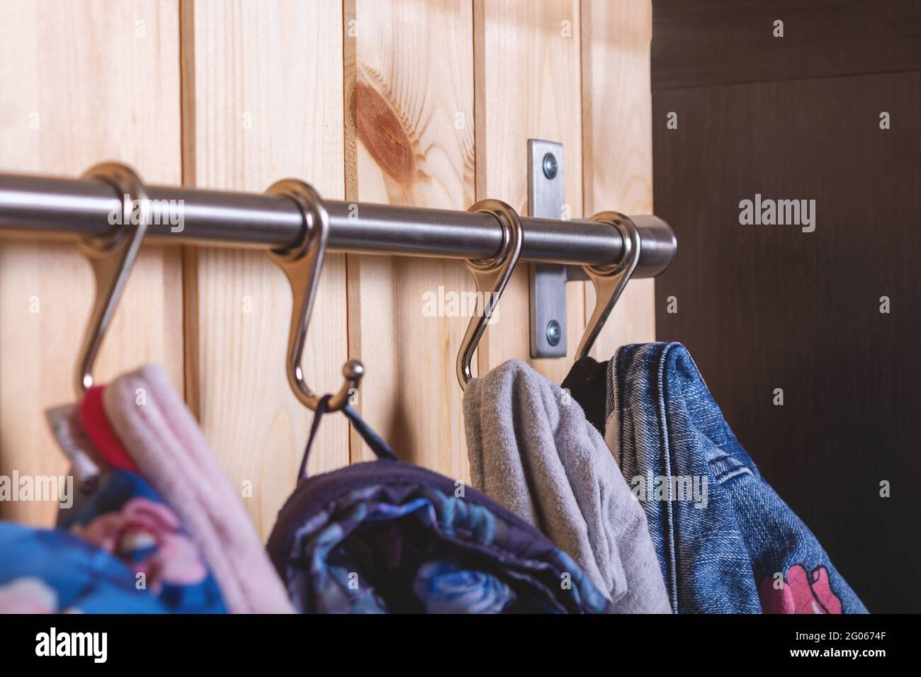 Kleiderbügel für Kinder an Metallhaken. Nahaufnahme. Stockfoto