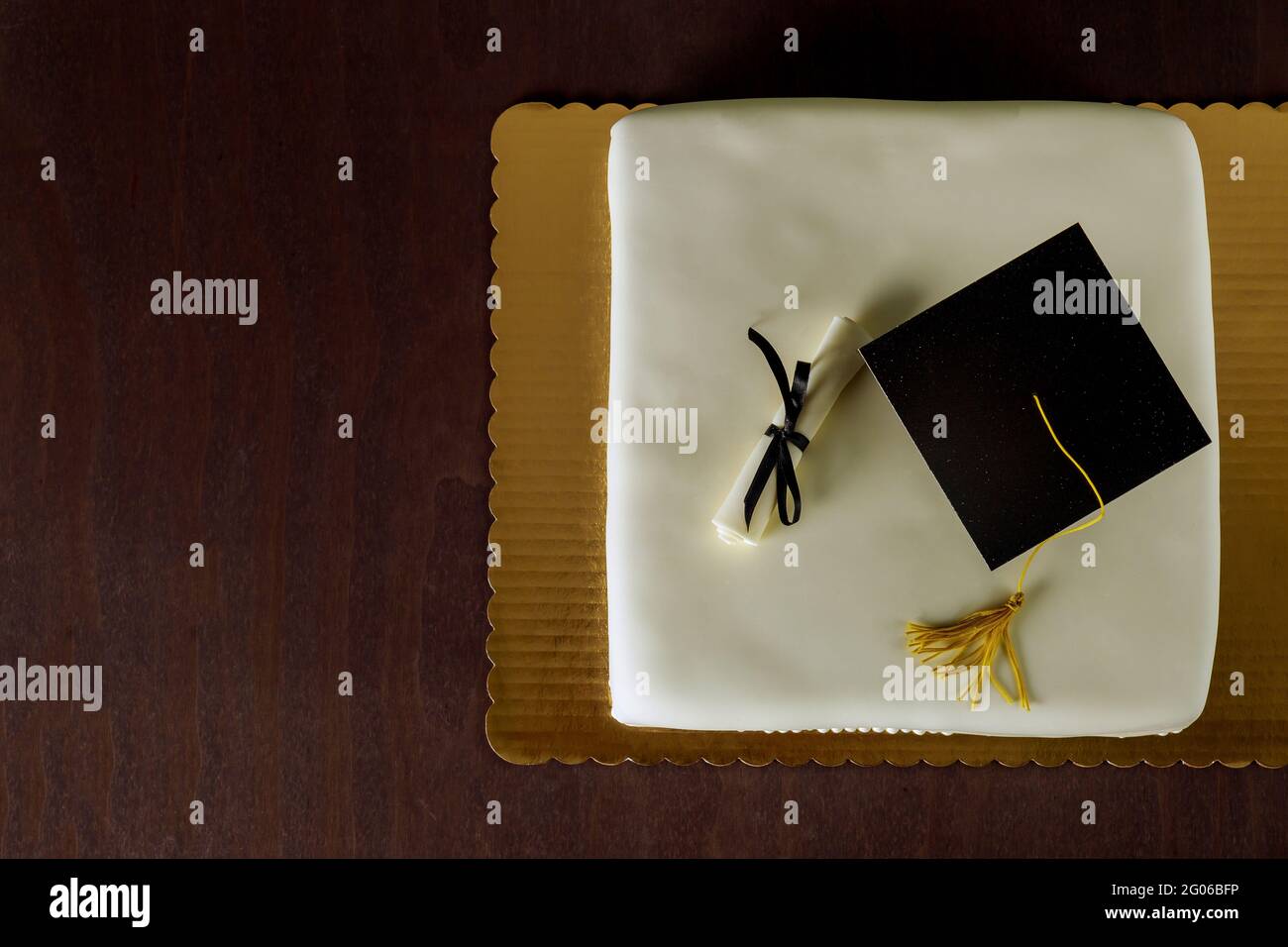 Graduierung weiße Kuchen mit Kappe auf der Oberseite und Diplom-Dekor. Draufsicht. Stockfoto