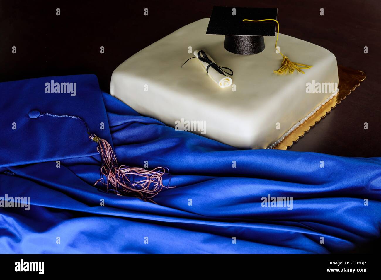 Blaues Kleid und Abschlusskappe mit Kuchen für Schulende. Stockfoto