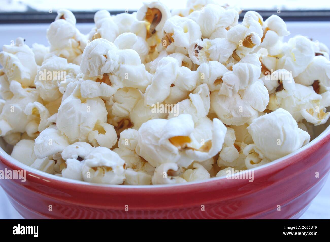 Nahaufnahme einer Schüssel Popcorn. Salzige und fetthaltige ungesunde Snacks. Hintergrund der Filmzeit. Stockfoto