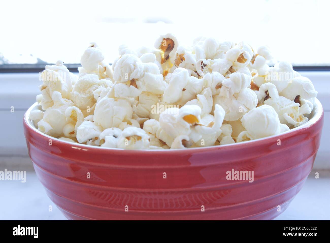 Nahaufnahme einer Schüssel Popcorn. Salzige und fetthaltige ungesunde Snacks. Hintergrund der Filmzeit. Stockfoto