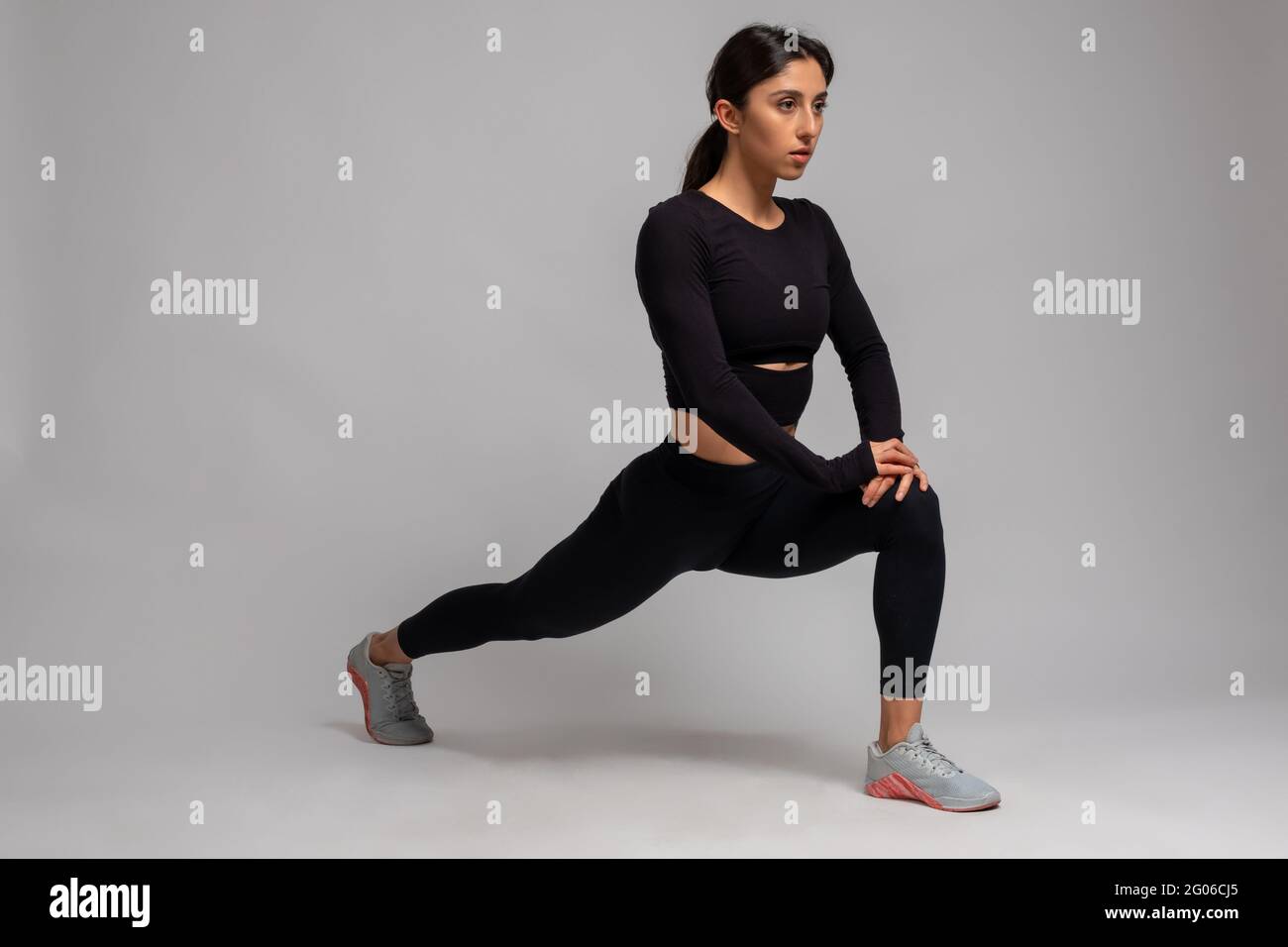 Junge Frau, die Stürme auf grauem Hintergrund ausführt Stockfoto