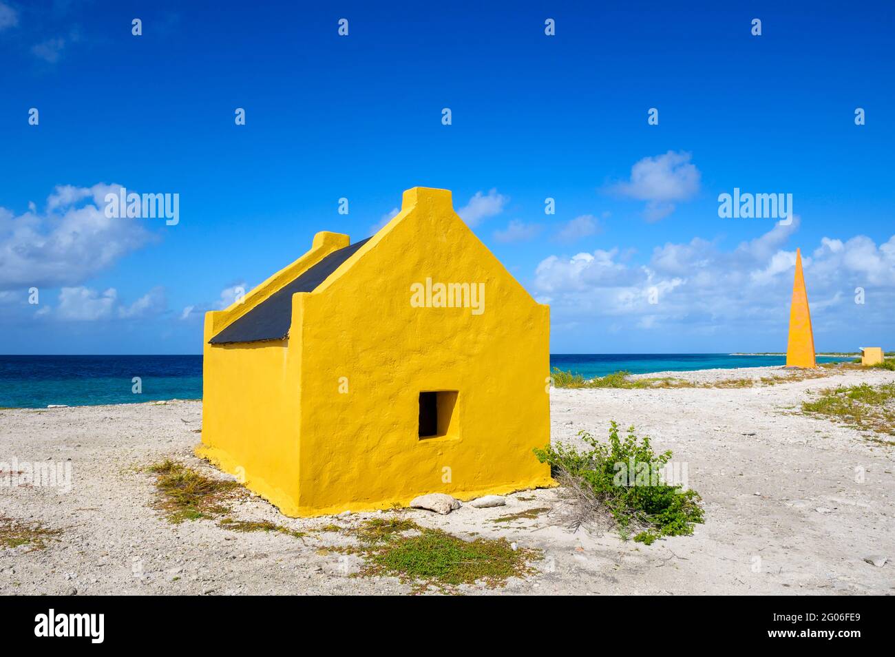 Gelbes ehemaliges Sklavenhaus und gelber Obelisk als Wahrzeichen für Schiffe, die Salz sammeln, Bonaire, niederländische Karibik. Stockfoto