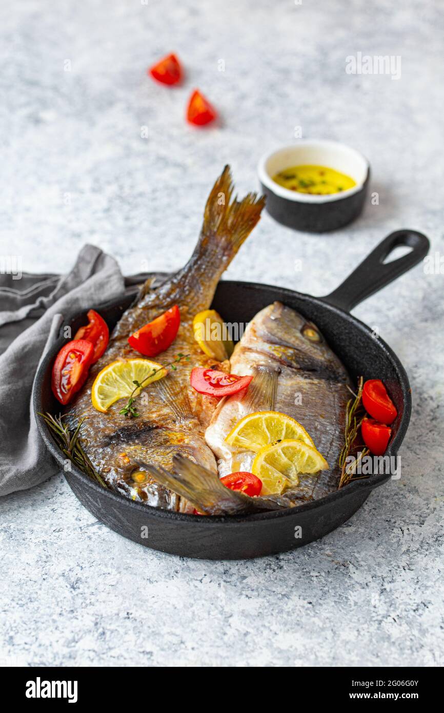 Gegrillter Fisch, Meeresbrasse oder dorado in gusseiserner Pfanne  Stockfotografie - Alamy