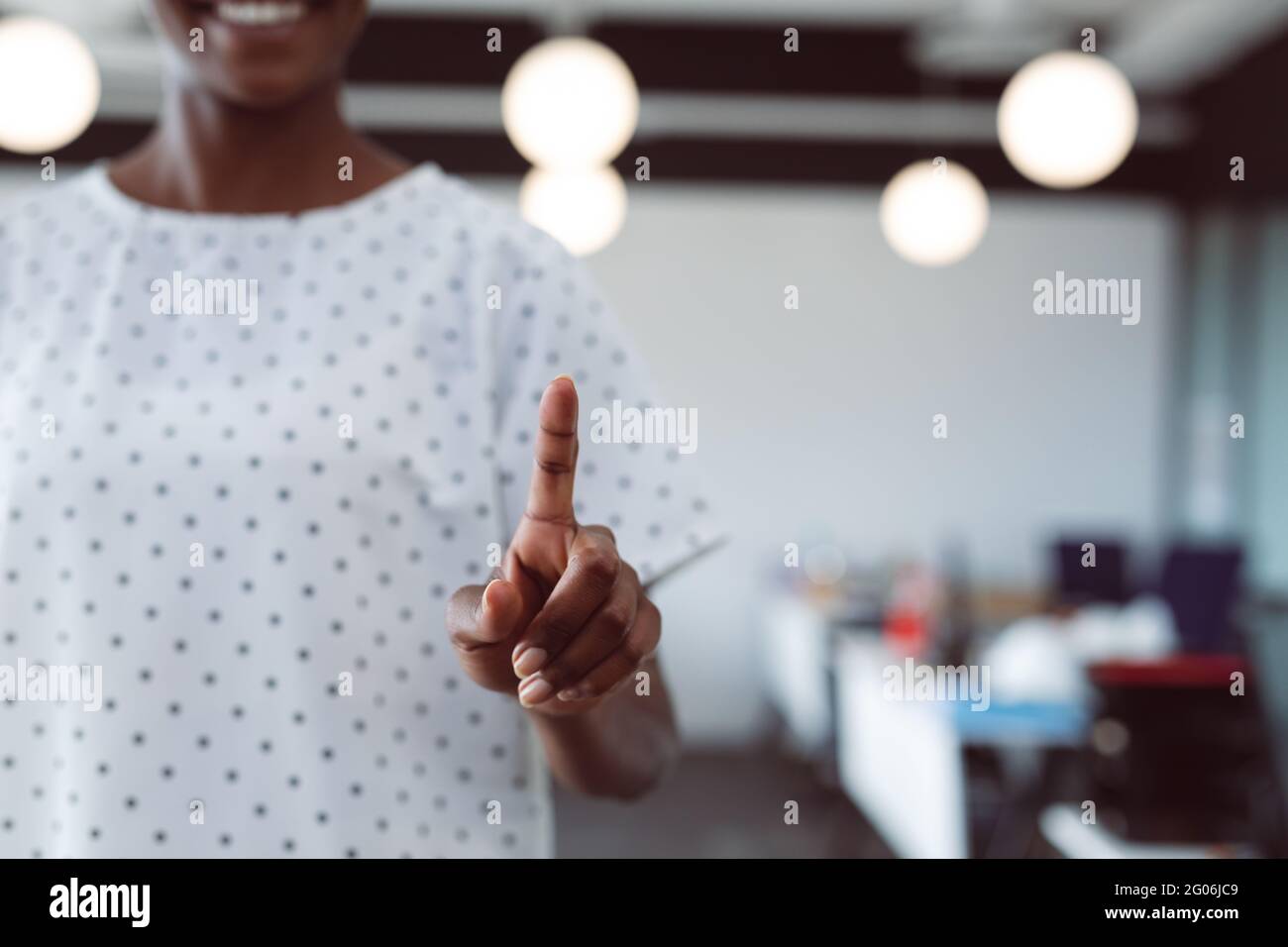 Nahaufnahme der Hand einer afroamerikanischen Geschäftsfrau, die den interaktiven Bildschirm berührt Stockfoto