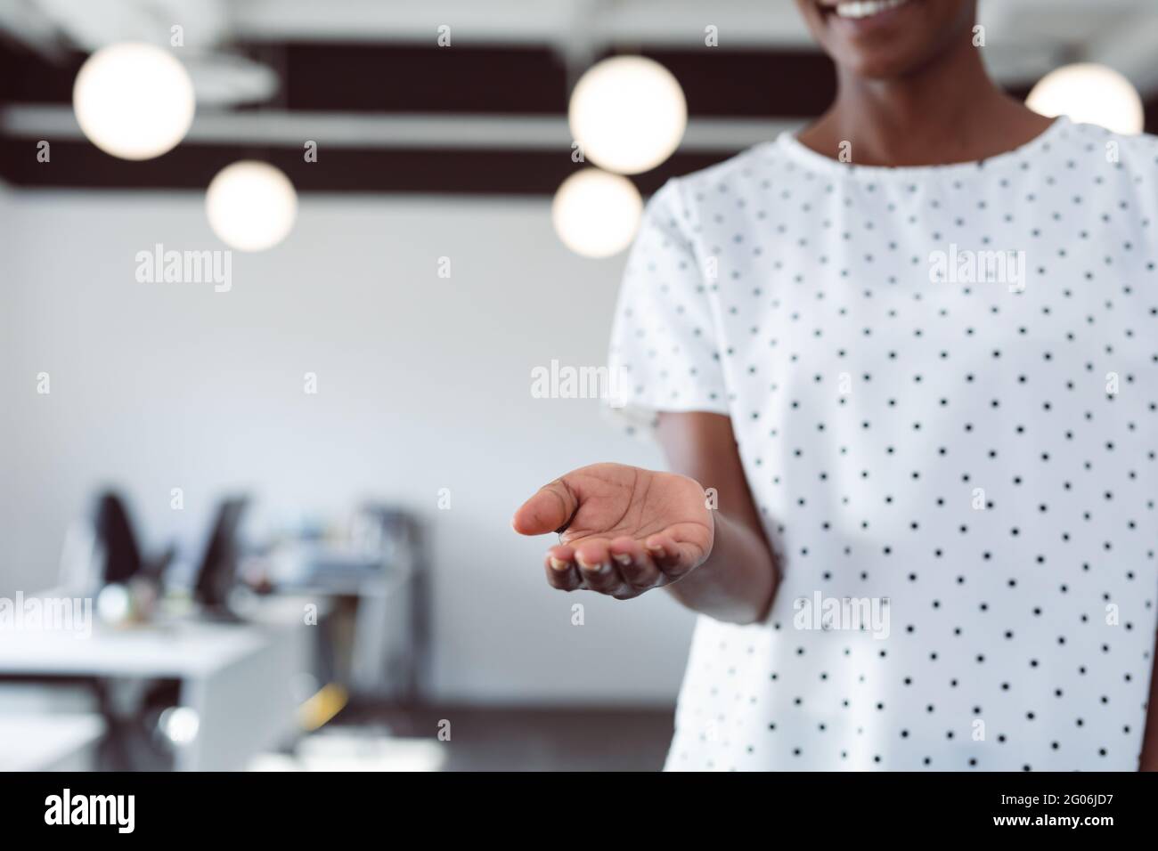 Mittelteil einer lächelnden afroamerikanischen Geschäftsfrau mit offener Hand Stockfoto