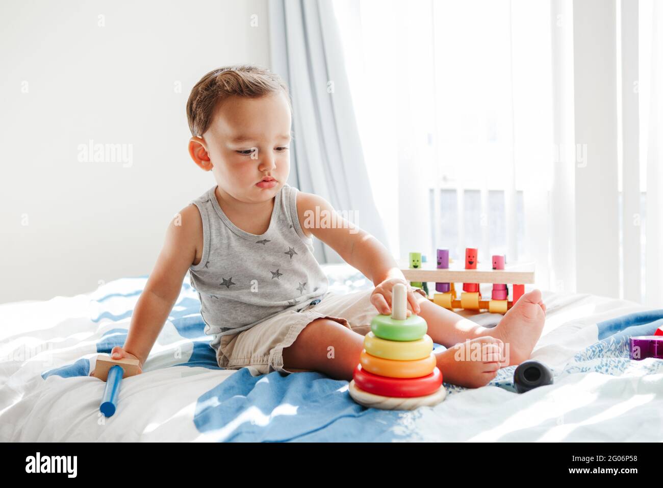 Nettes Baby Kleinkind spielen mit Lernspielzeug Pyramide Stapelblöcke zu Hause. Frühes Alter Montessori Ausbildung. Kinder Hand Gehirn Spaß Entwicklung Aktivität Stockfoto