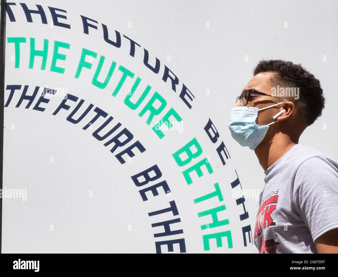 Am 1. Juni 2021 laufen Menschen in kovidierten Masken auf der Oxford Street an einem Schild mit der Aufschrift „BE THE FUTURE“ vorbei. Stockfoto