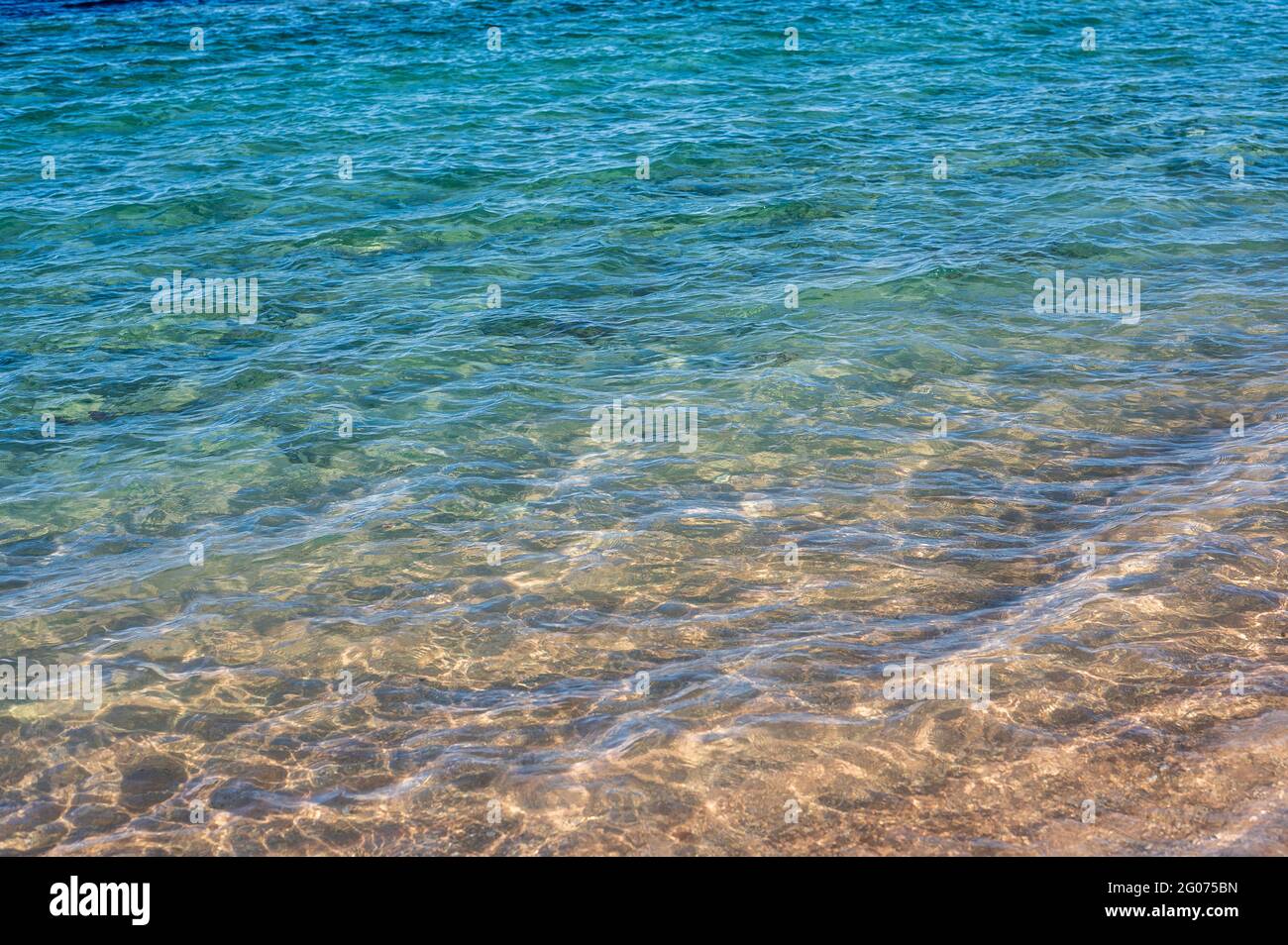 Abstrakter Meereshintergrund. Abstrakter Sandstrand im Sommer mit blauem Meer. Wunderschöne Textur. Speicherplatz kopieren Stockfoto