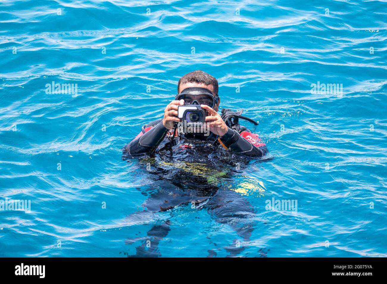 Unterwasserfotograf Videograf Tauchgänge auf der Oberfläche des Meeres. Unterwasserfotografie und Videografie Konzept Stockfoto
