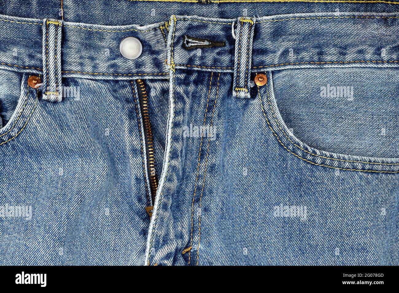 Nahaufnahme einer Jeans in Denim-Blau mit ungezippten Reißverschlüssen Stockfoto
