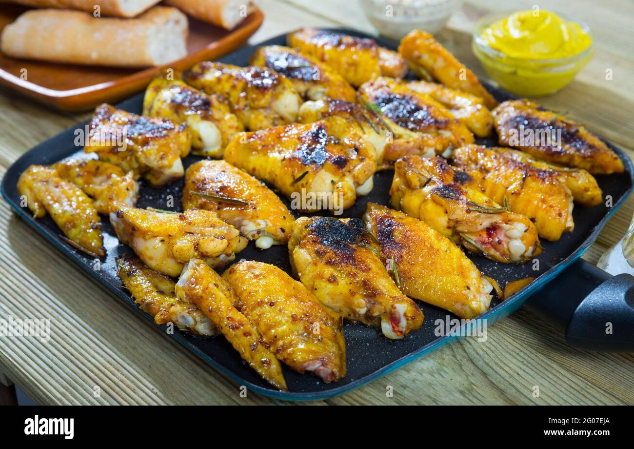Hähnchenflügel auf Frypan mit Sauce Stockfoto