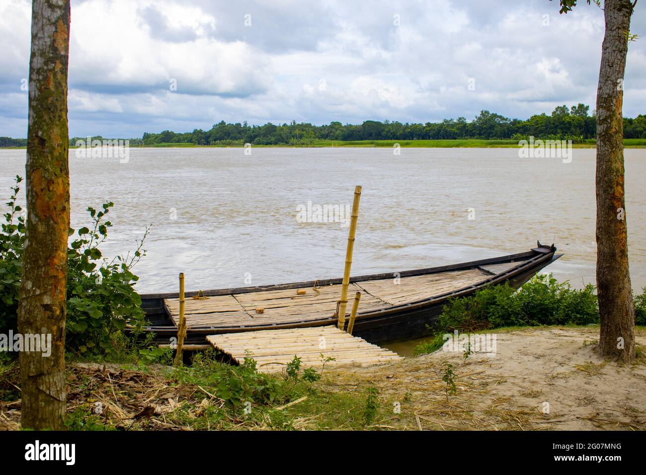 Ein großes Holzboot, das an das Flussufer gebunden ist. Dies ist ein großes Flusskreuzboot. Ein wunderschöner Fluss von Bangladesch. Stockfoto