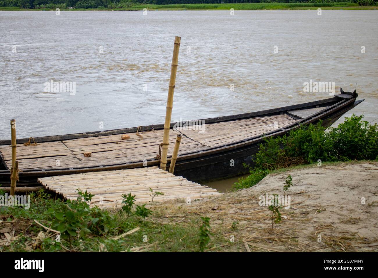 Ein großes Holzboot, das an das Flussufer gebunden ist. Dies ist ein großes Flusskreuzboot. Ein wunderschöner Fluss von Bangladesch. Stockfoto