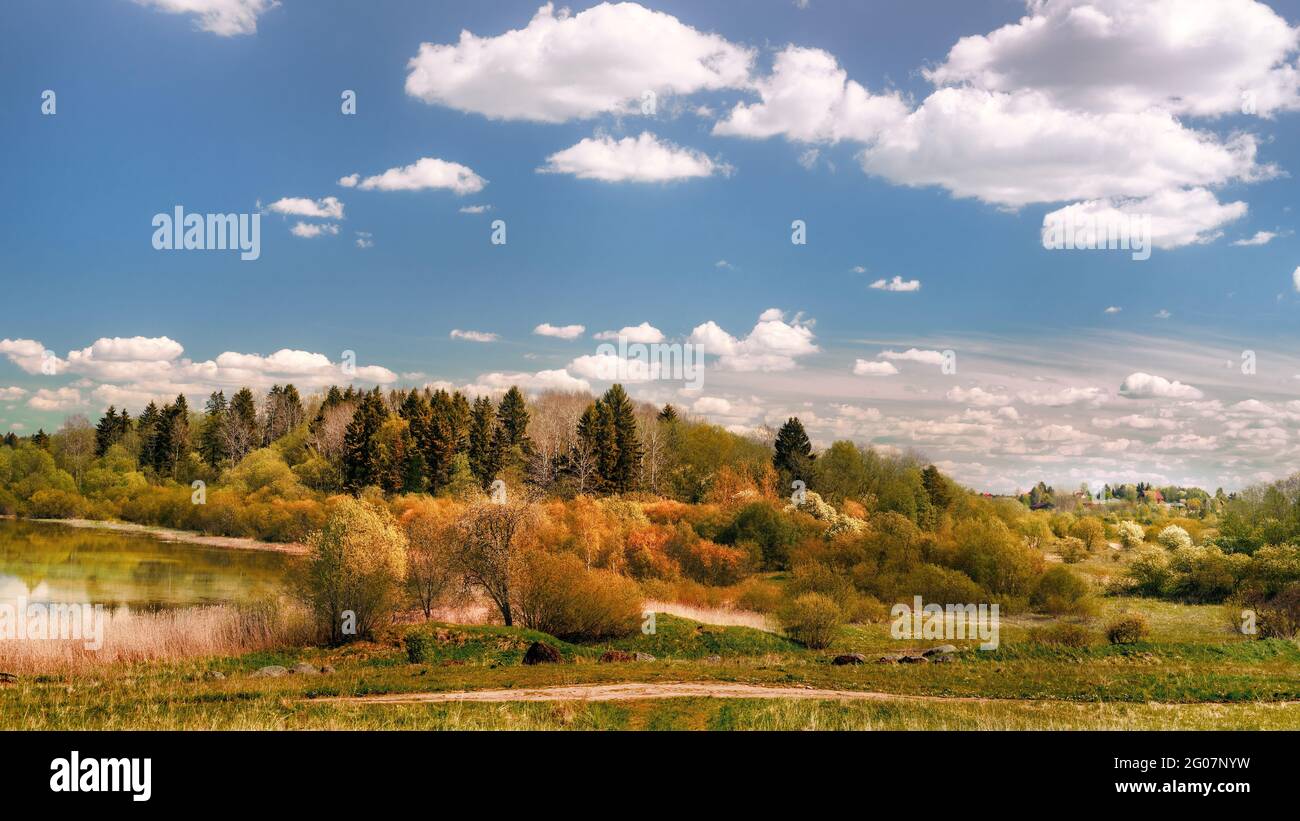 Weitwinkel Panoramablick auf See, bewaldeten Hügel und kleines Dorf. Ländliche herbstfarbene Landschaft Stockfoto