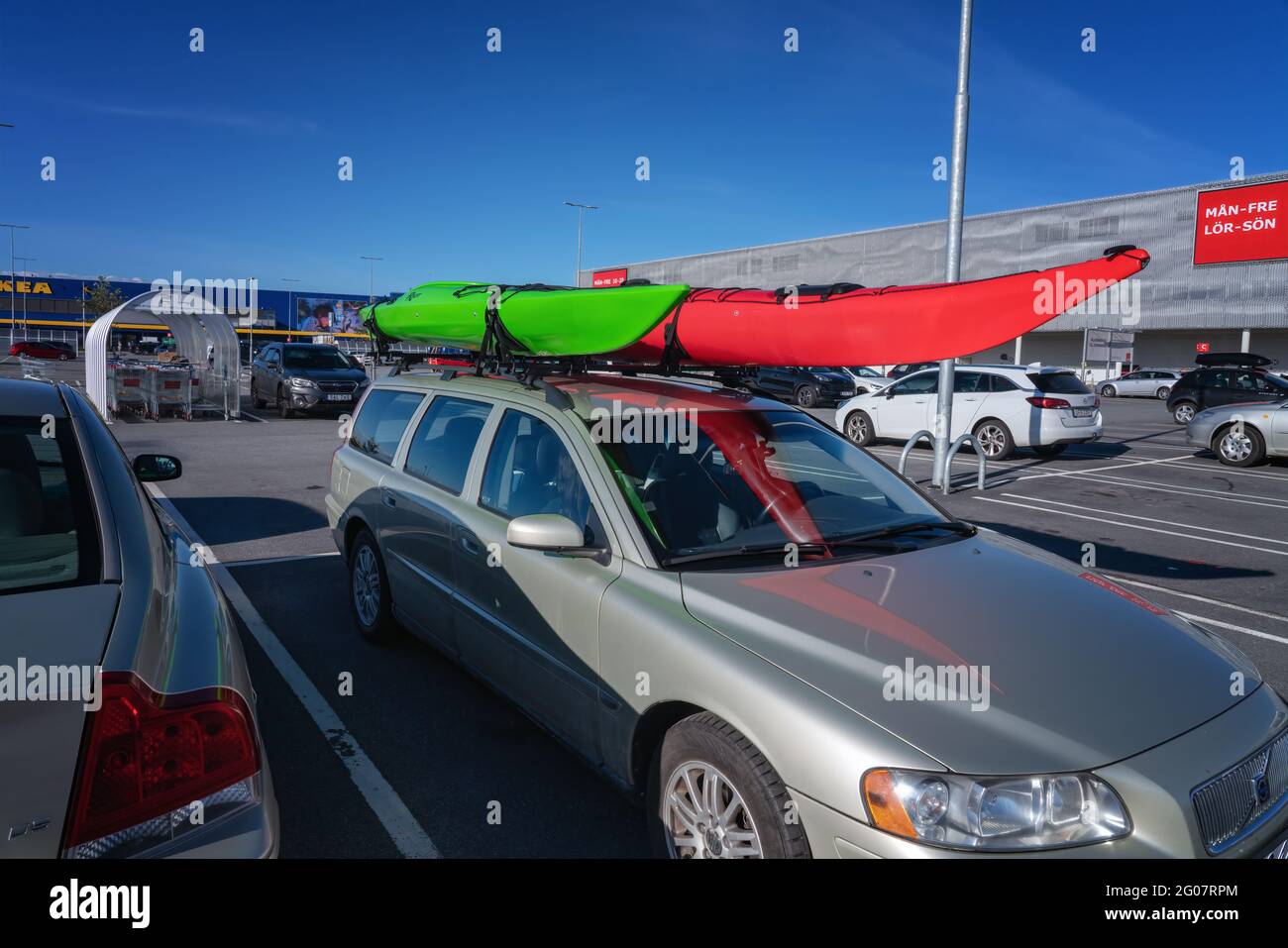 UMEA, SCHWEDEN - 1. JUNI 2021: Kajakfahren: Ein Executive-Auto mit zwei montierten Kajaks, das auf dem öffentlichen Parkplatz im Einkaufszentrum Avion, Umea City, geparkt ist. S Stockfoto