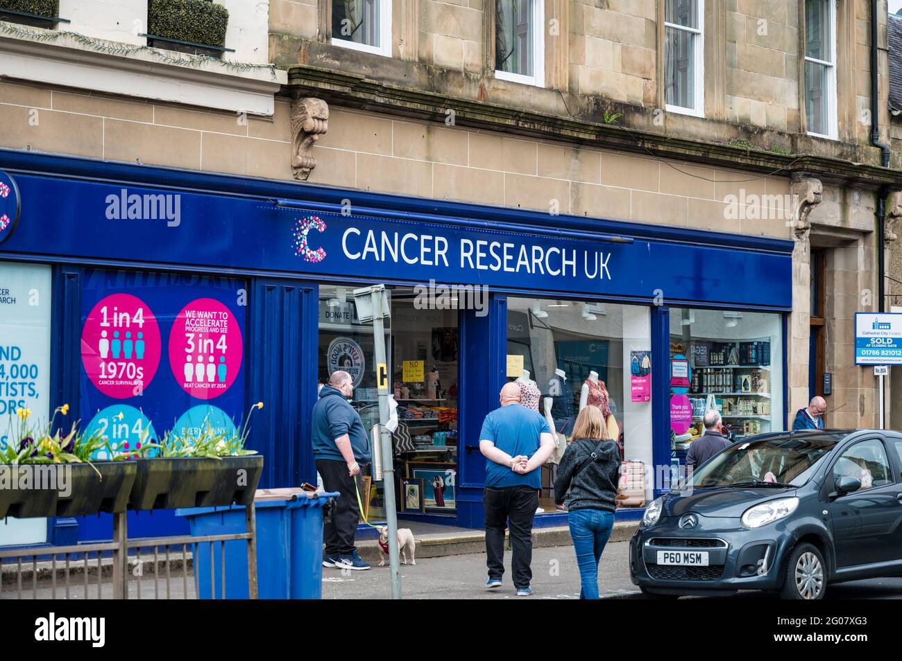 Callander, Schottland - 29. Mai 2021: Das Geschäft vorne und Schild für Cancer Research UK Stockfoto