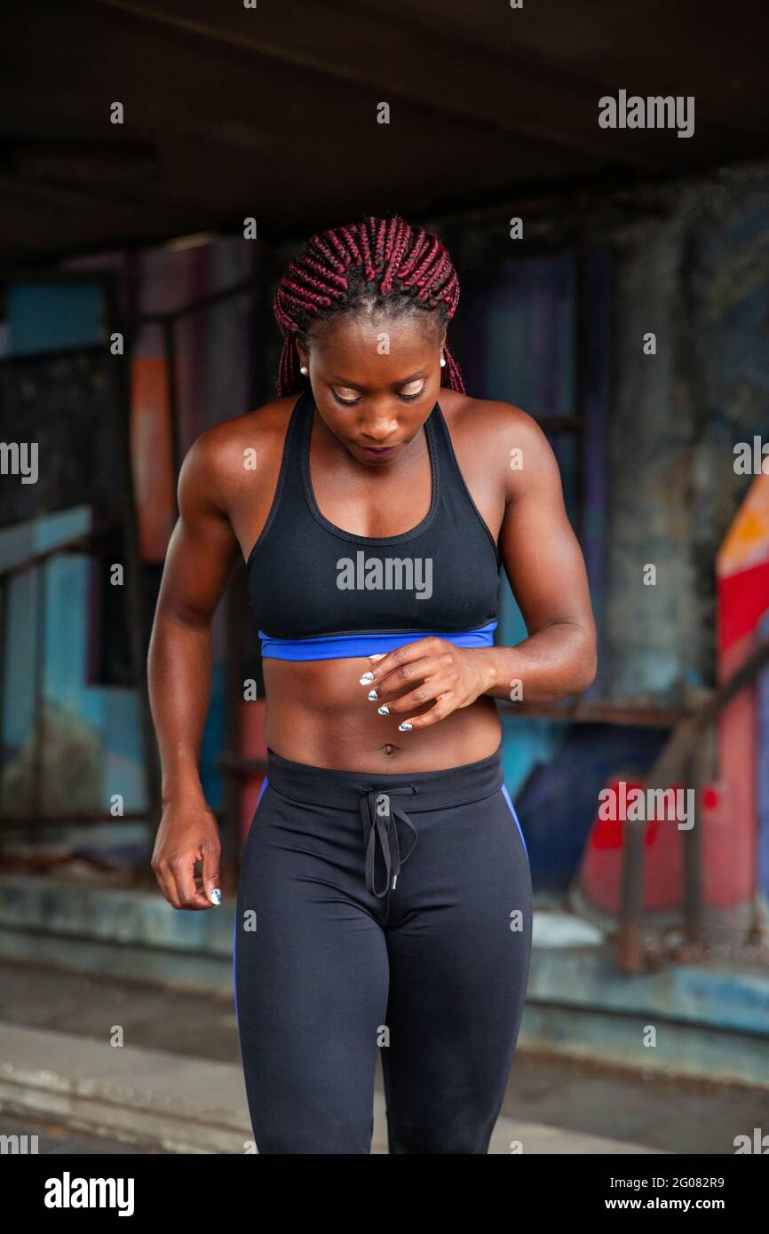 Positive schwarze Frau auf verschwommenem Hintergrund der Stadtstraße Stockfoto