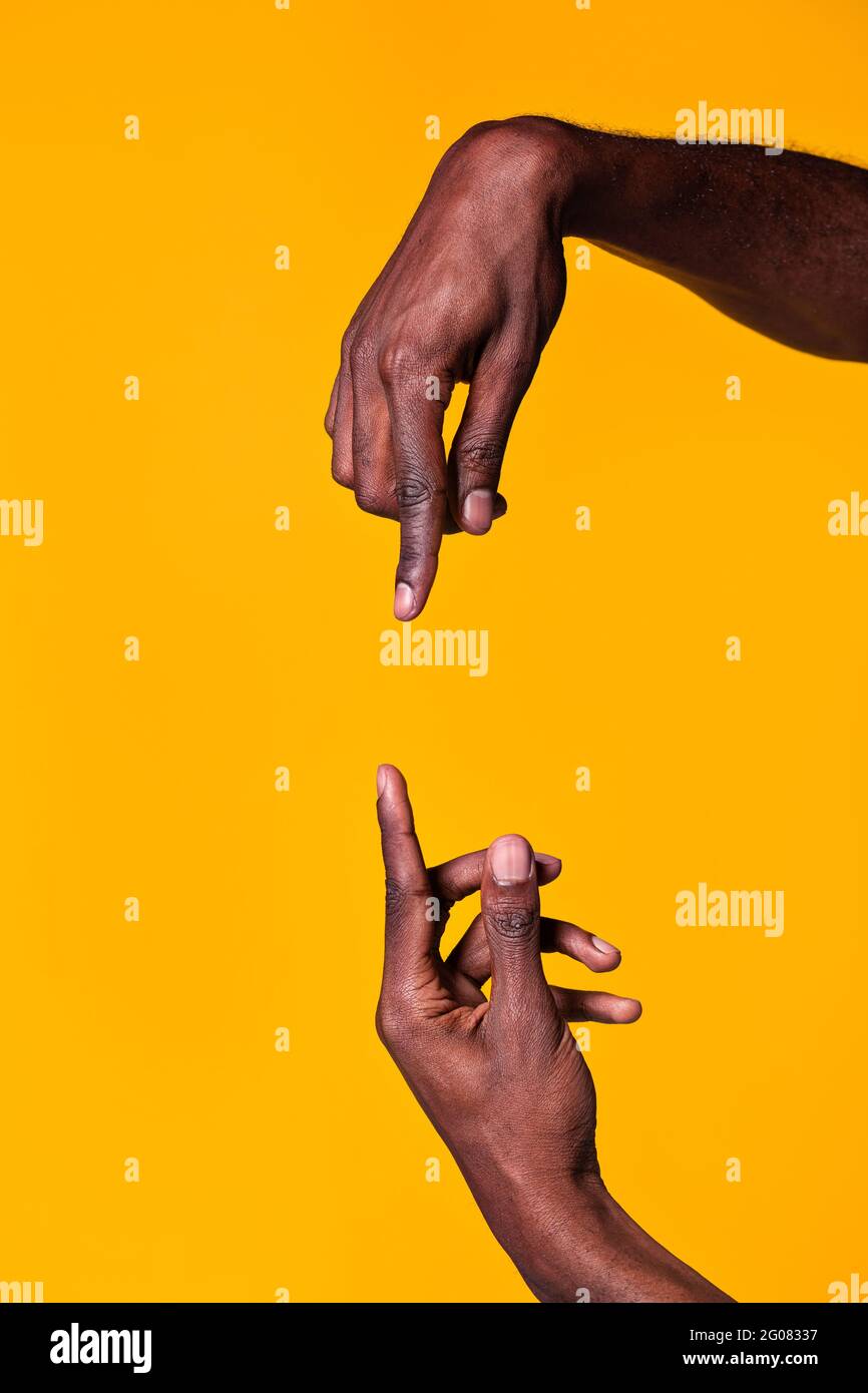 Gegensätzliche Hände afroamerikanischer Männer, die sich mit Witz anzeigten Zeigefinger auf gelbem Hintergrund isoliert Stockfoto