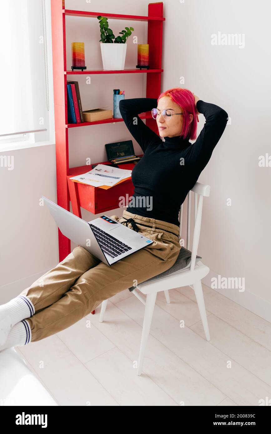 Ganzkörper-Seitenansicht aktiver Frauen, die auf dem Skateboard springen, während sie während des Trainings in der Stadt Stunt auf dem Sportplatz durchführen Stockfoto