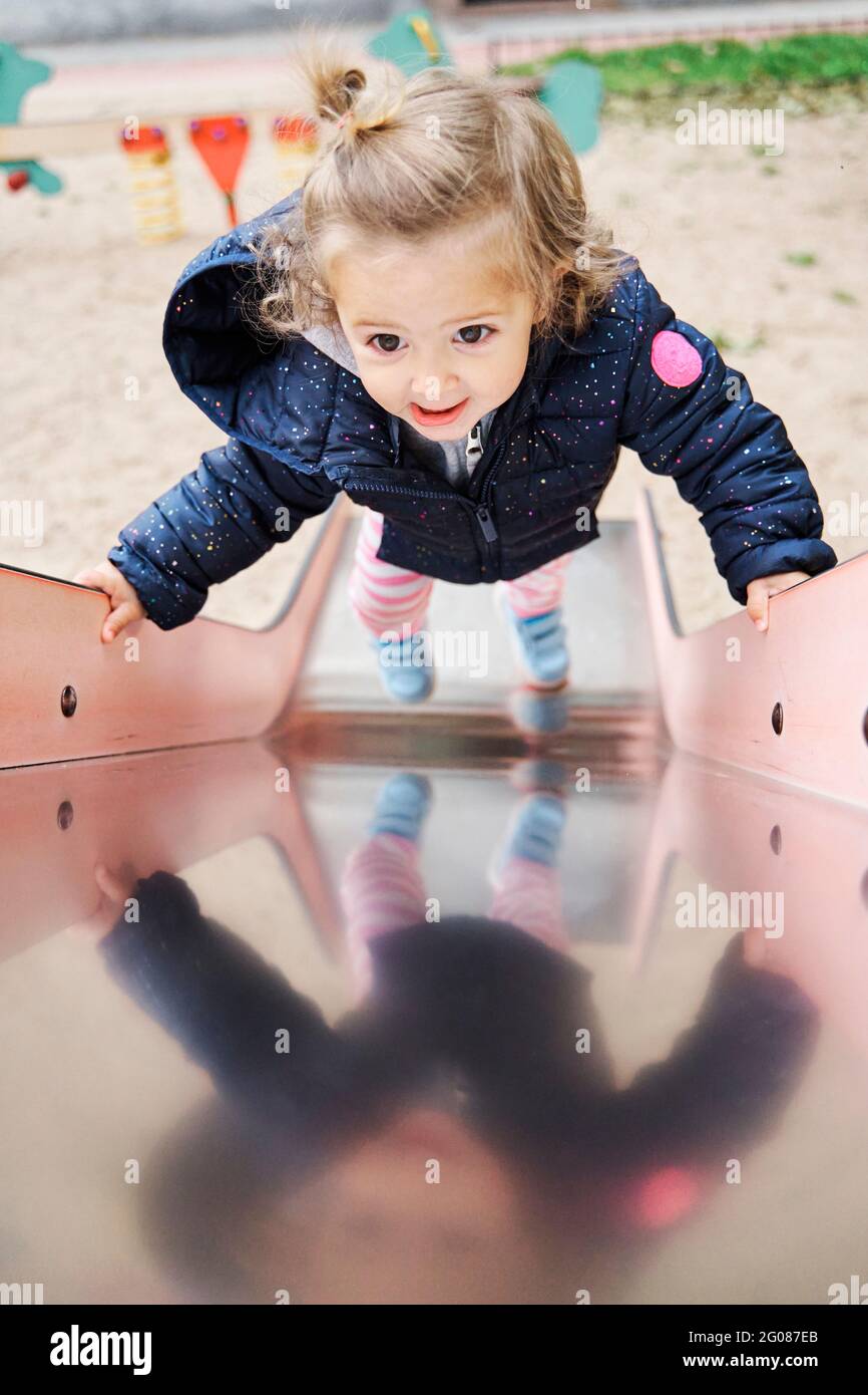 Kleinkind Mädchen spielt auf einer Rutsche auf einem Spielplatz Stockfoto