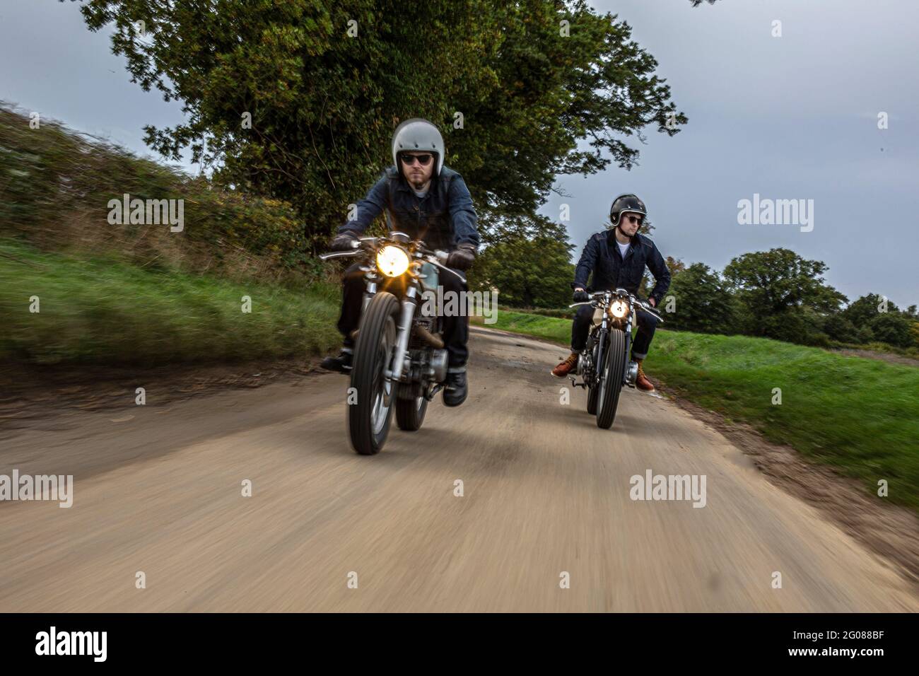 Vorderansicht von zwei Motorrädern und Fahrern auf der Straße.zwei Motorradfahrer auf einer Landstraße. Stockfoto
