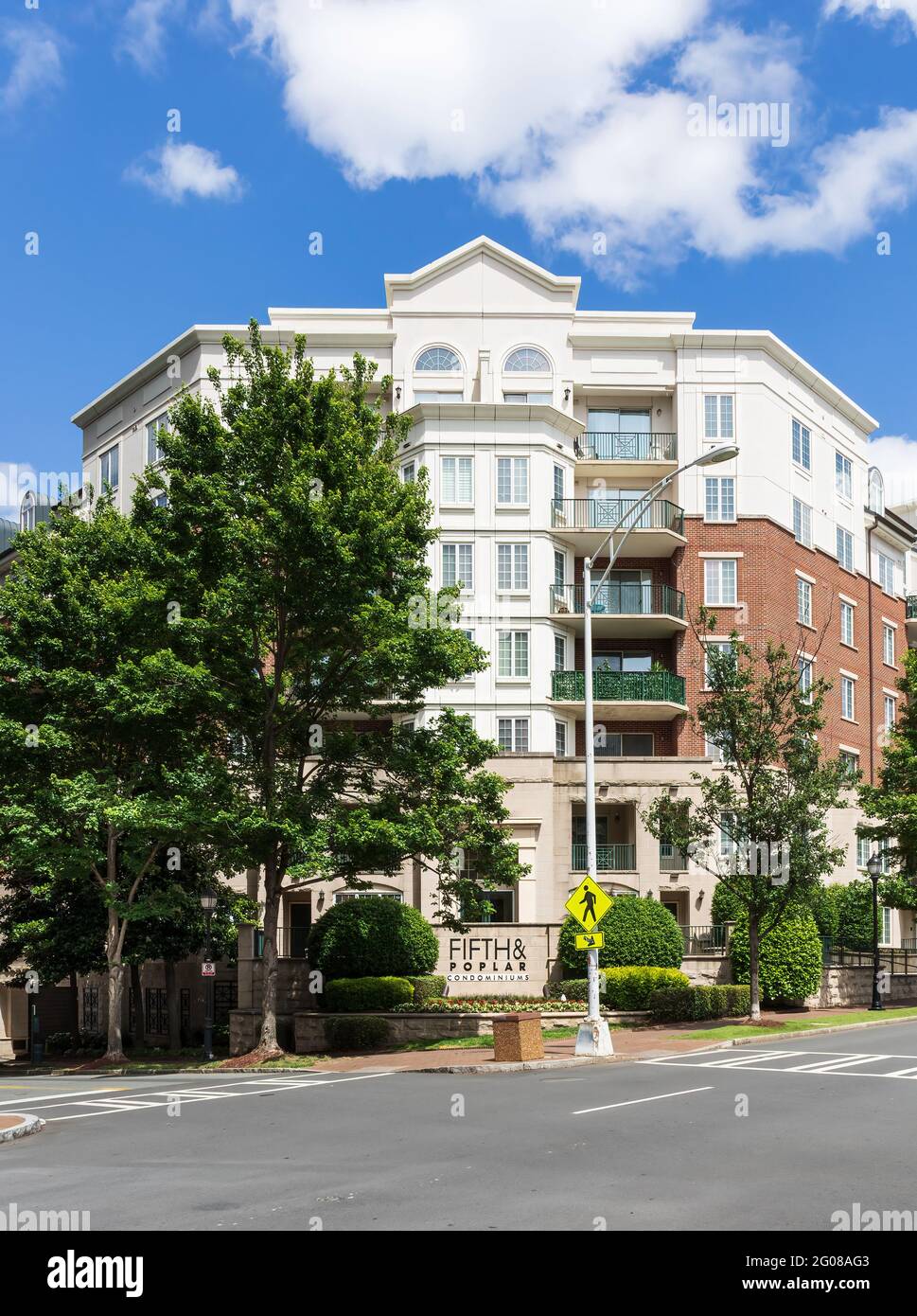 CHARLOTTE, NC, USA-30 MAY 2021: Blick auf die Straßenecke des Fifth and Poplar Condo Complex, unter blauem Sommerhimmel. Stockfoto