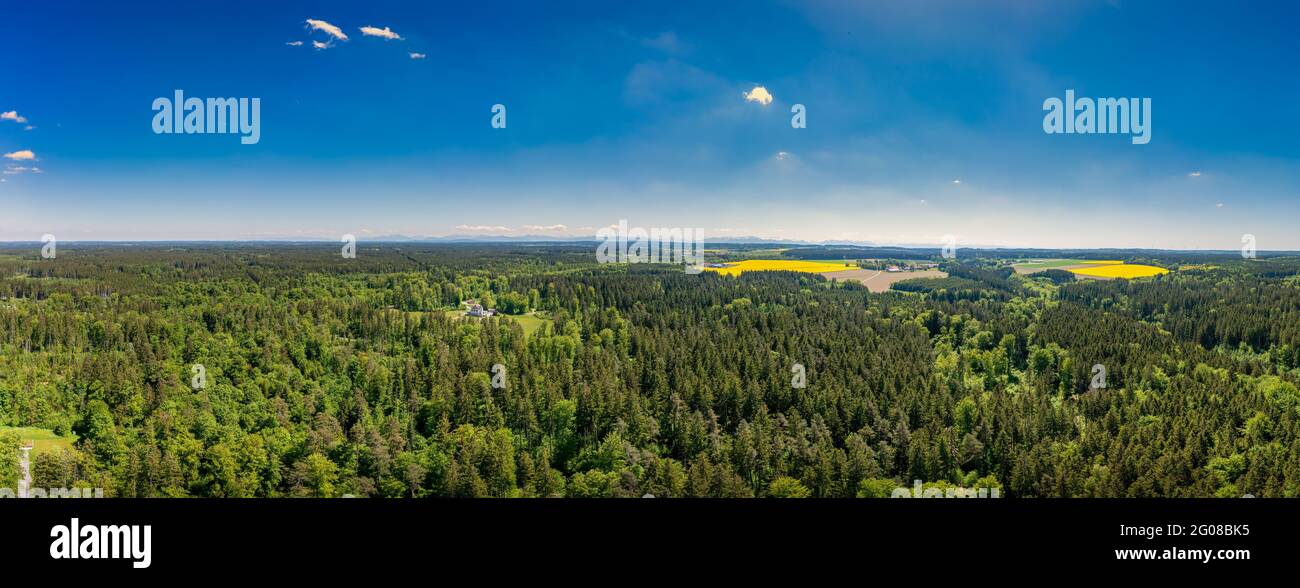 Idyllisches Wohnen zwischen einem grünen, frisch gelüfteten Wald in Panoramalage an einem sonnigen Tag im Frühling, bayern deutschland. Stockfoto