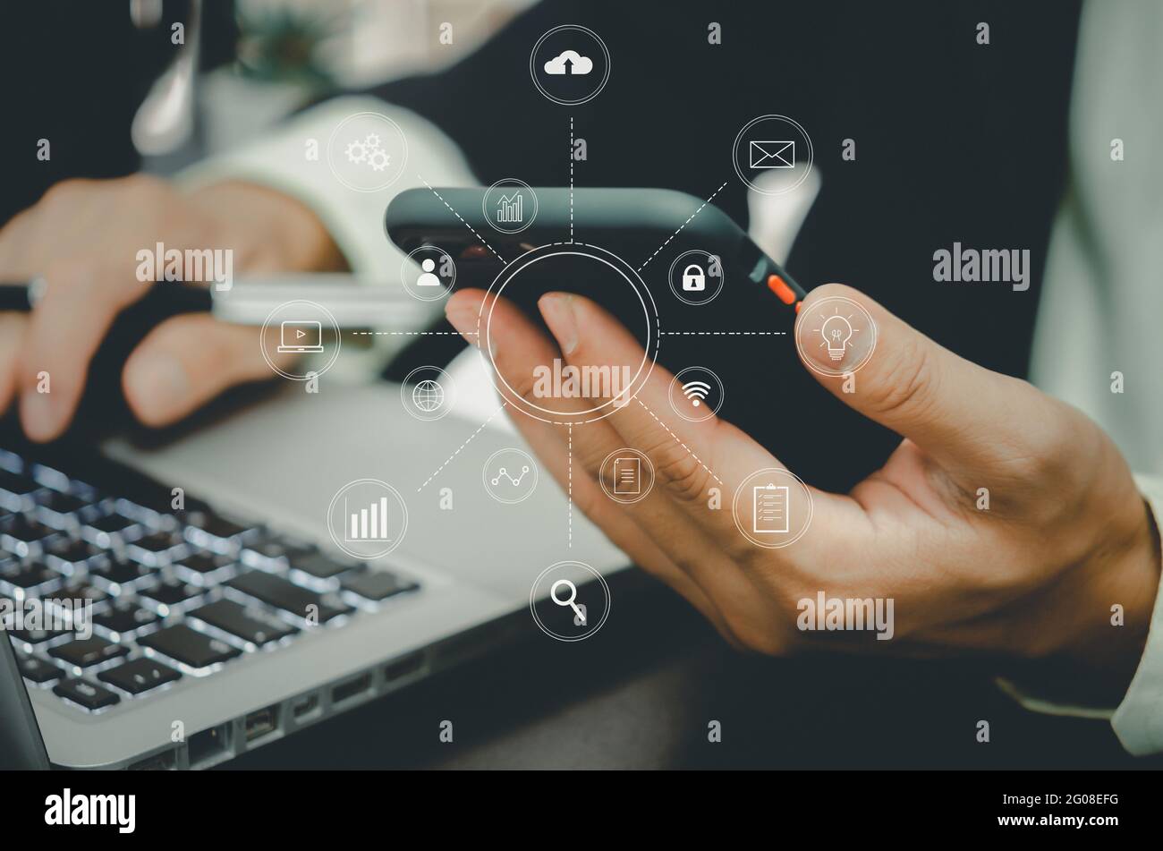 Geschäftsmann, der mit Smartphone und Laptop-Computer mit digitalen Marketing-Grafik Business-Finanz-Technologie Konzept Medien in virtuellen Ikone bei der Stockfoto