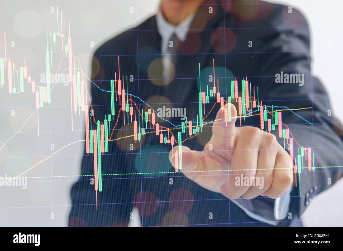 Geschäftsmann trägt einen Anzug zeigt Finger Aktienmarketing-Finanzierung auf moderne virtuelle Schnittstelle. Stockfoto