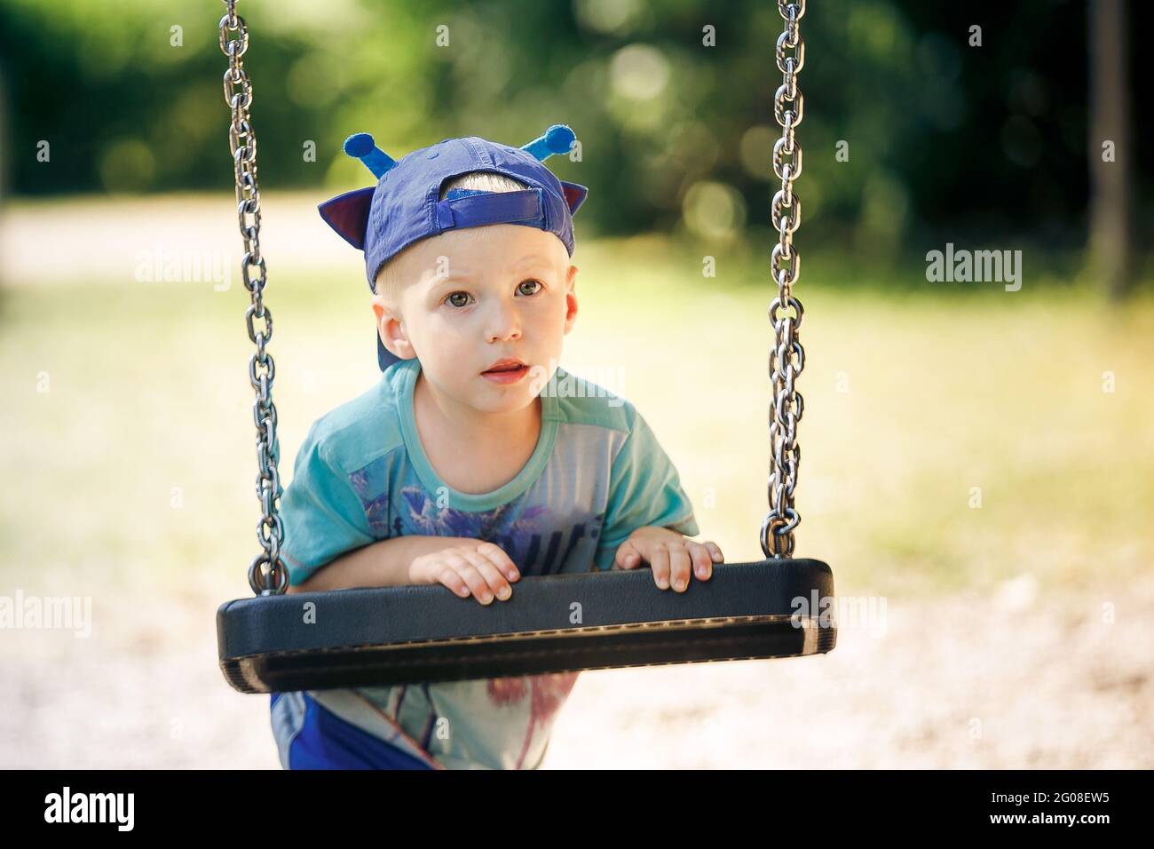 Porträt eines kleinen Jungen, der im Park mit Schaukel spielt Stockfoto
