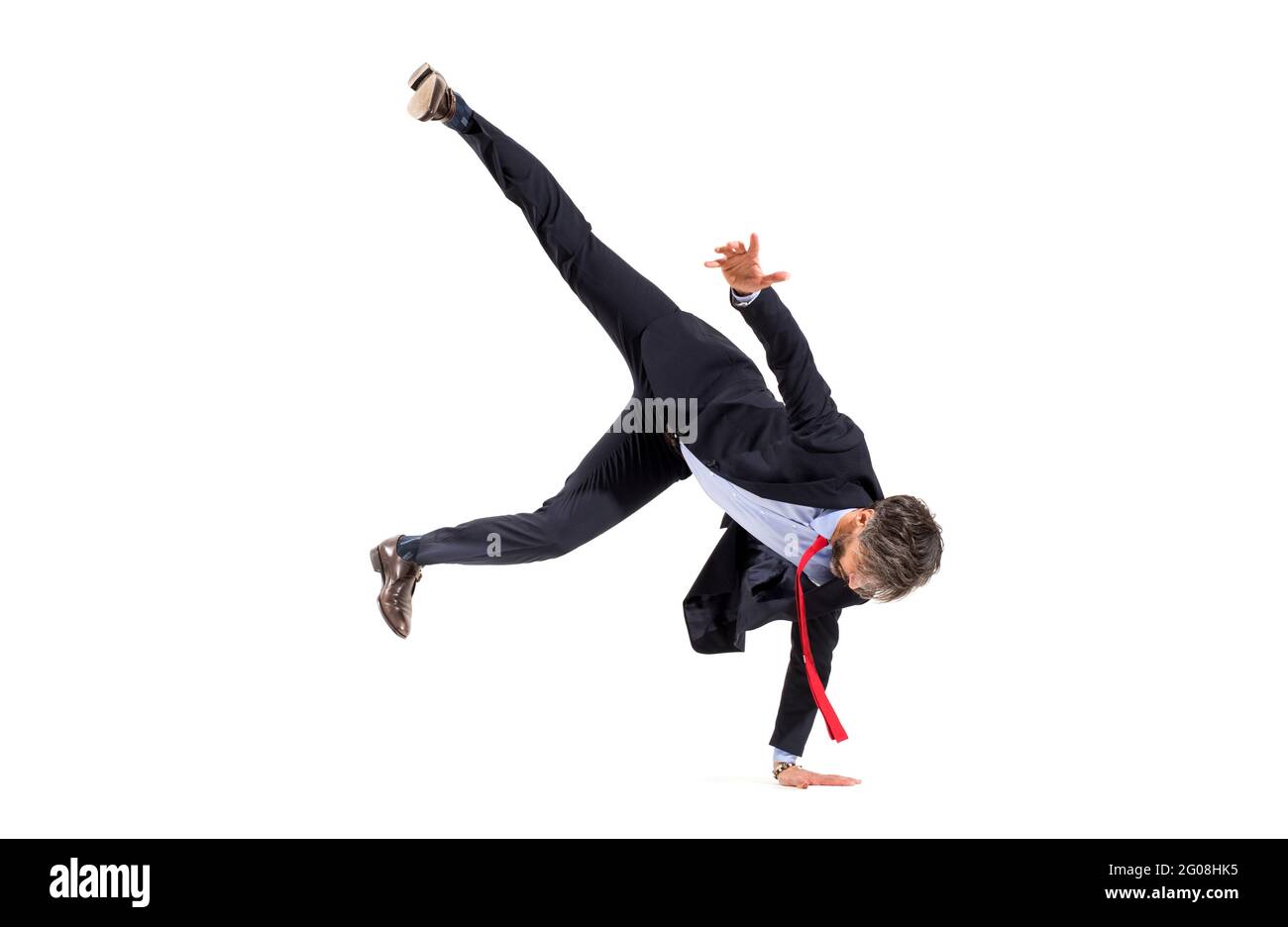 Stilvoller Geschäftsmann in einem Anzug, der Hip-Hop-Tanz auf einer Hand mit Beinen in der Luft balanciert, isoliert auf einem weißen Studiohintergrund mit Copyspace Stockfoto